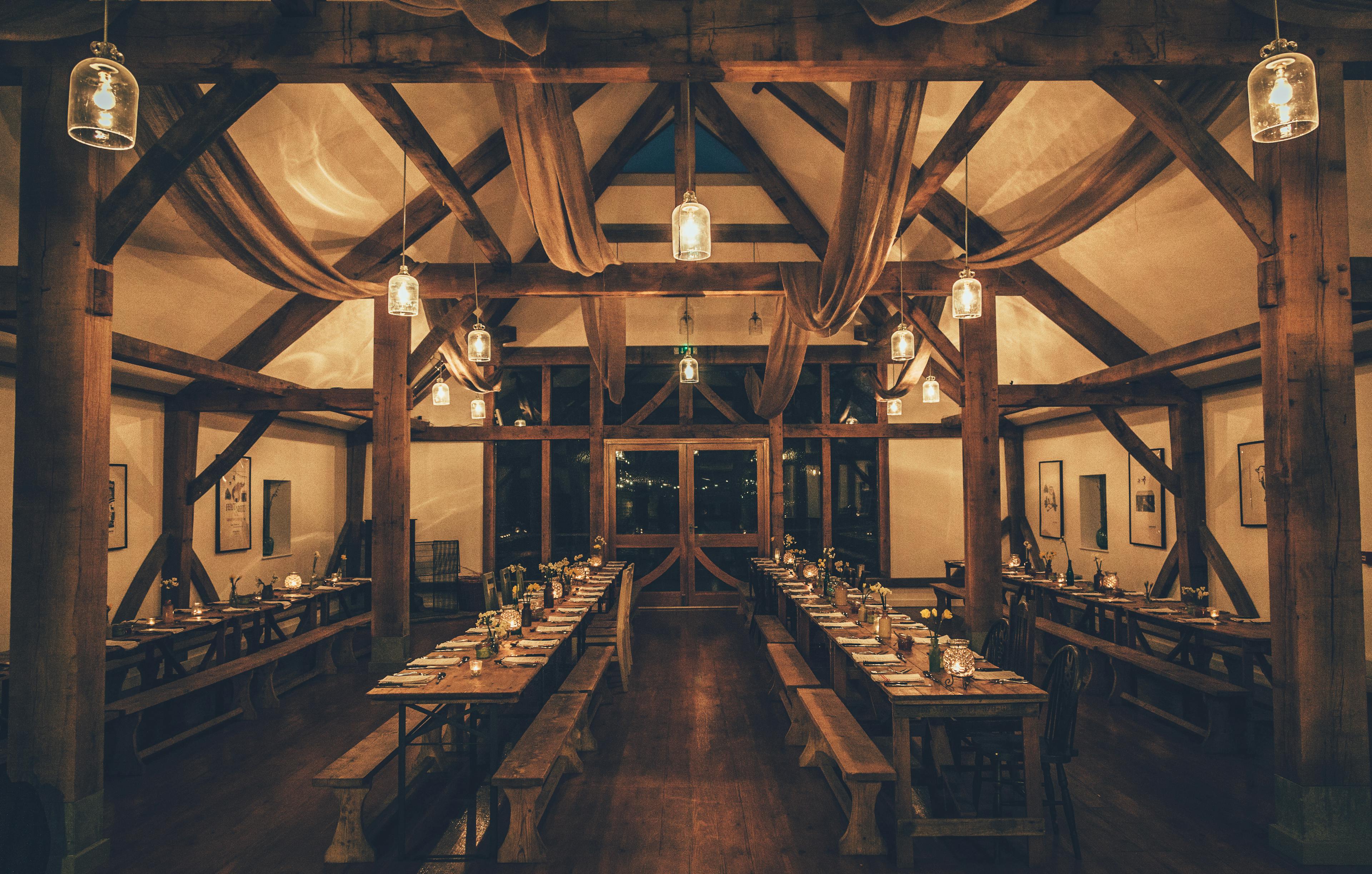 Tables are set for a wedding in an oak framed wedding barn