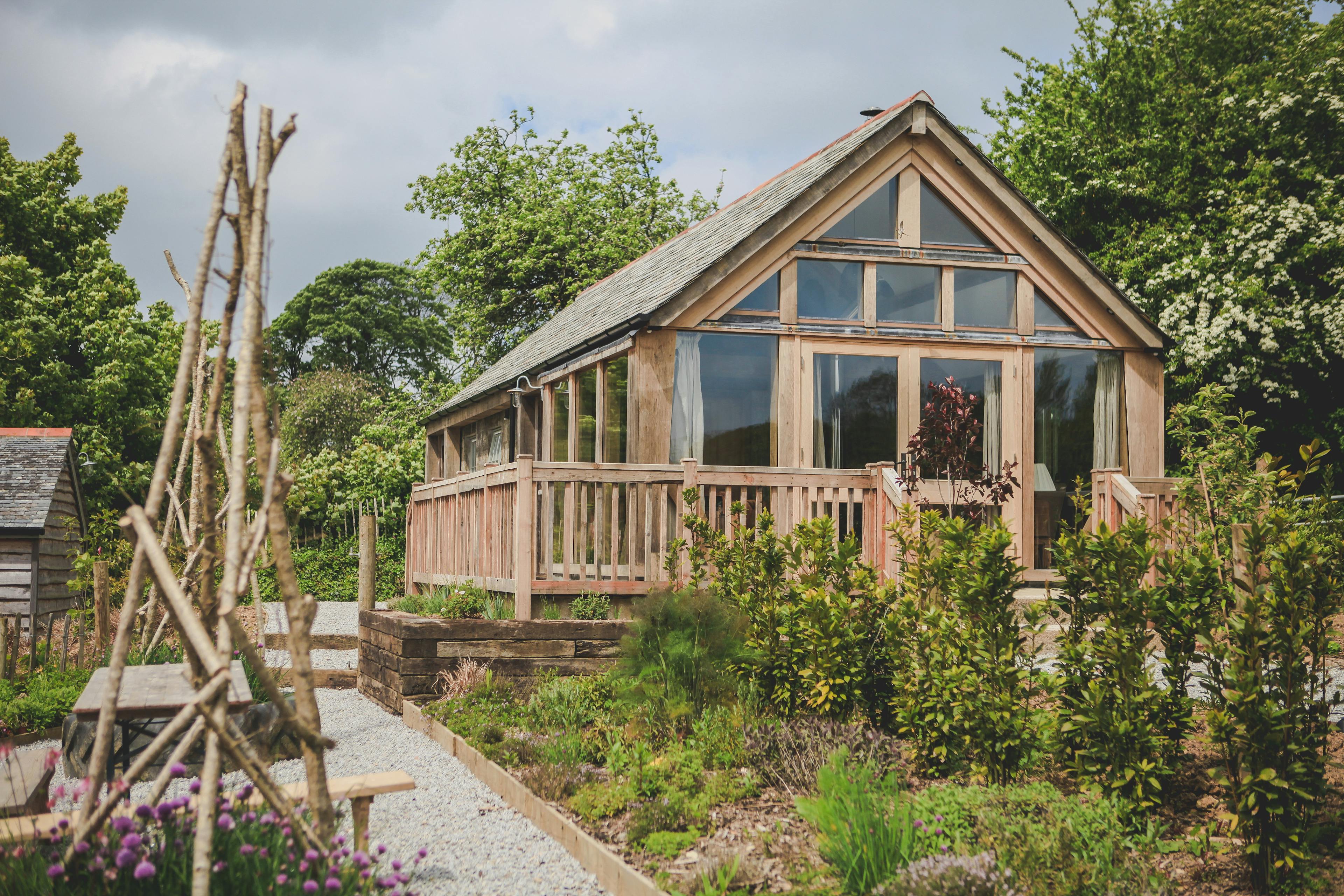 An oak framed cabin with a direct glazing set in a garden