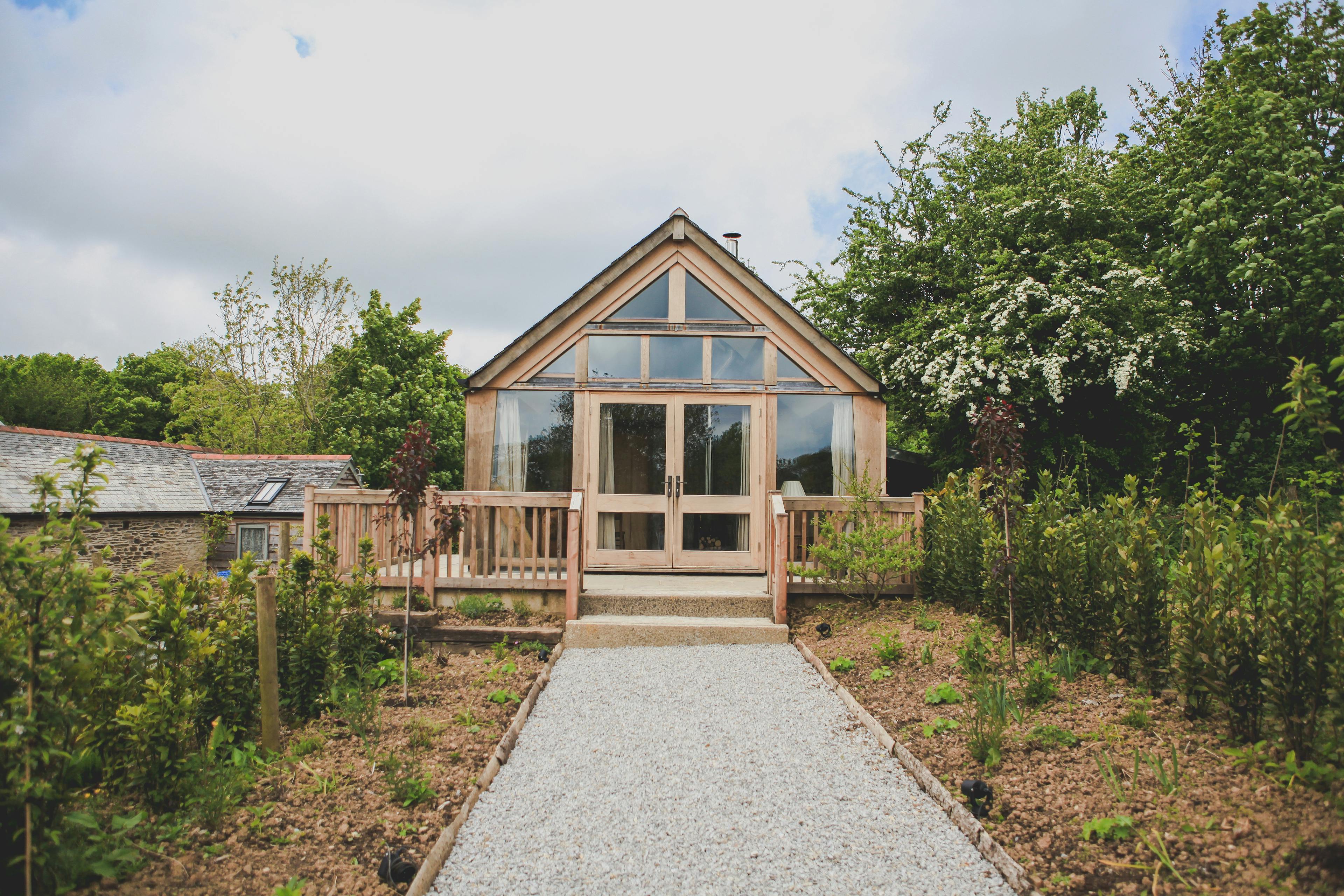 The path leading up to an oak framed cabin with a glazed gable end and direct glazing