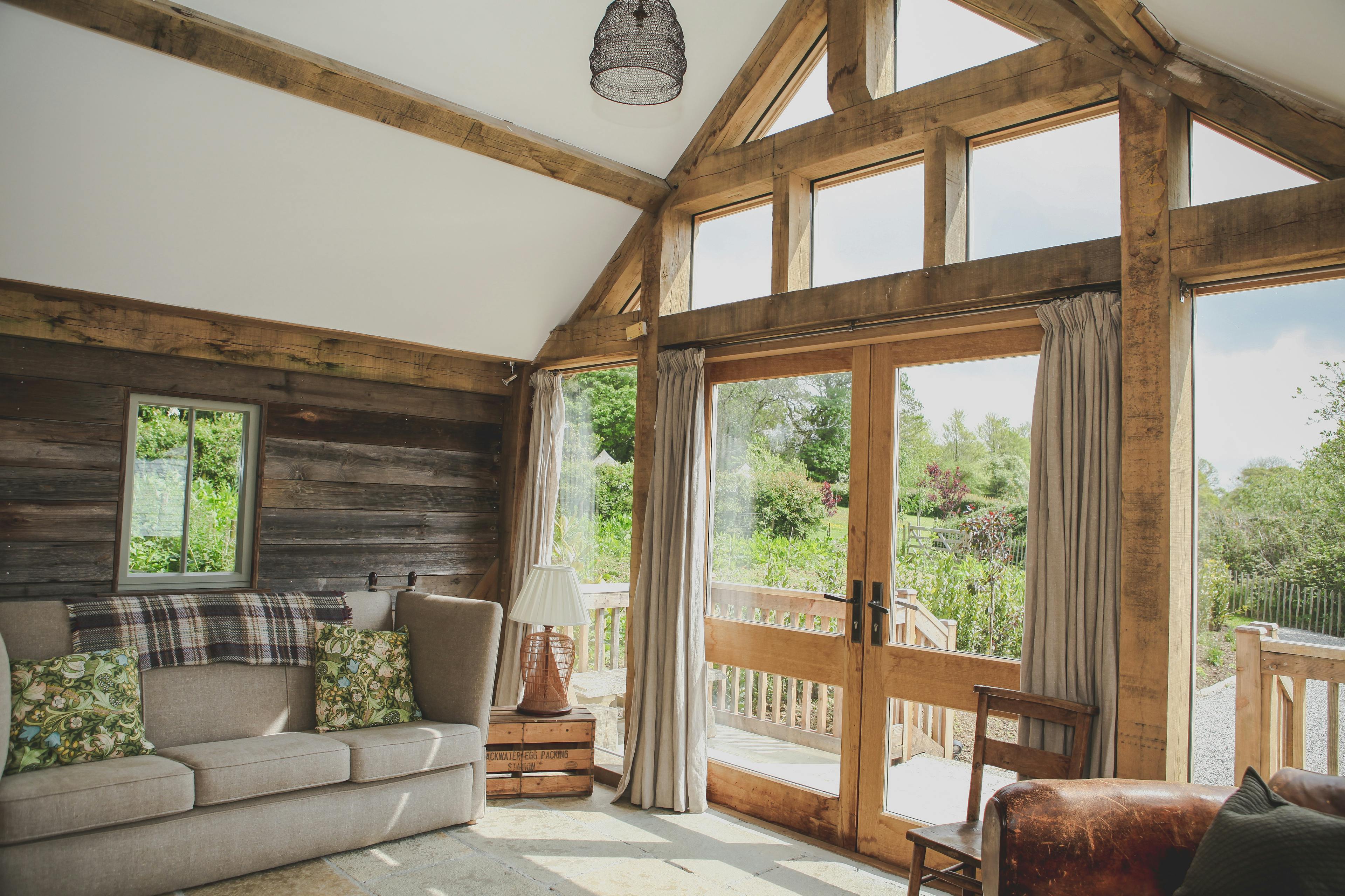 A sofa inside an oak framed cabin with a direct glazing