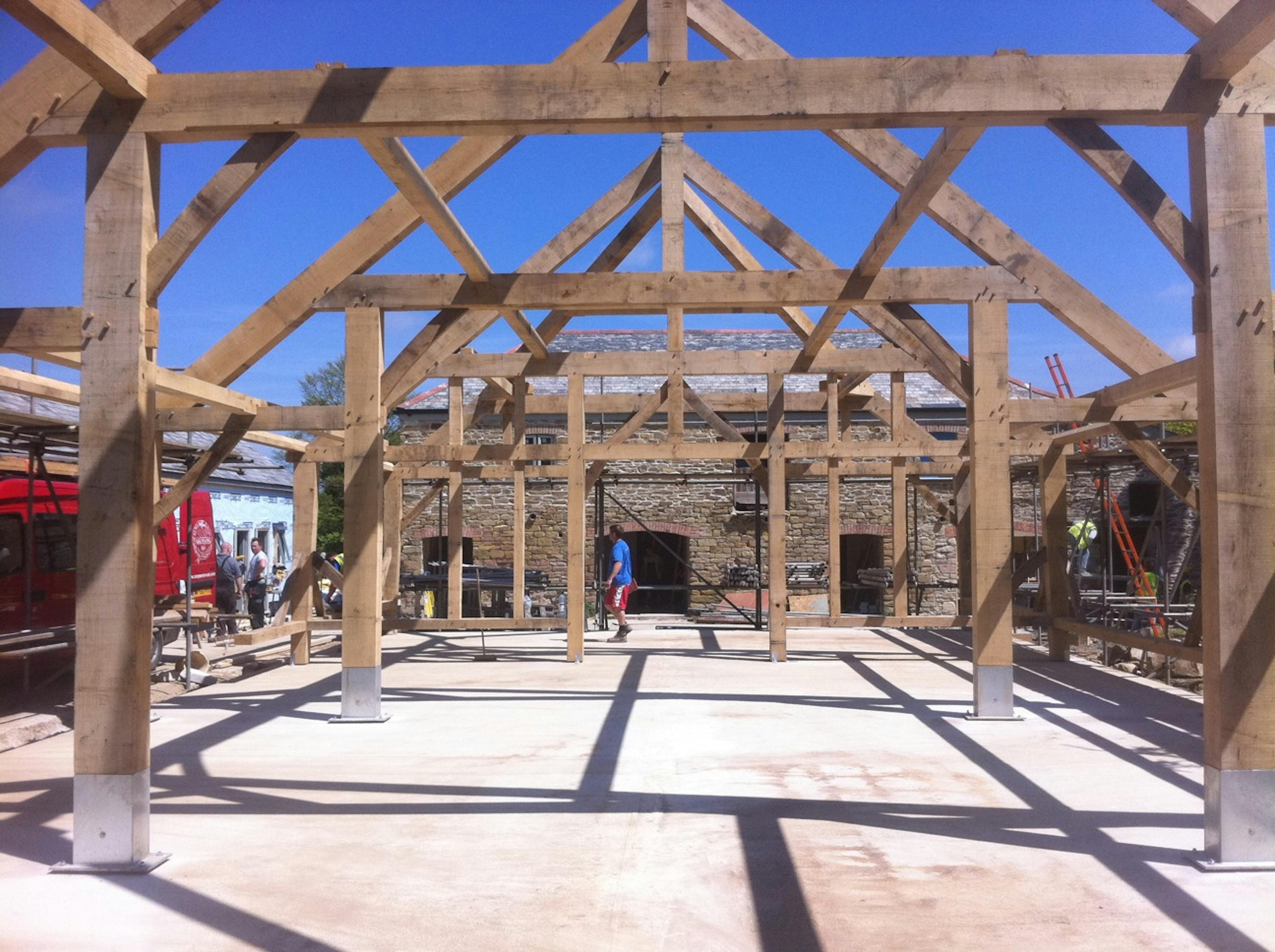 On a construction site the frame for an oak framed wedding barn is installed