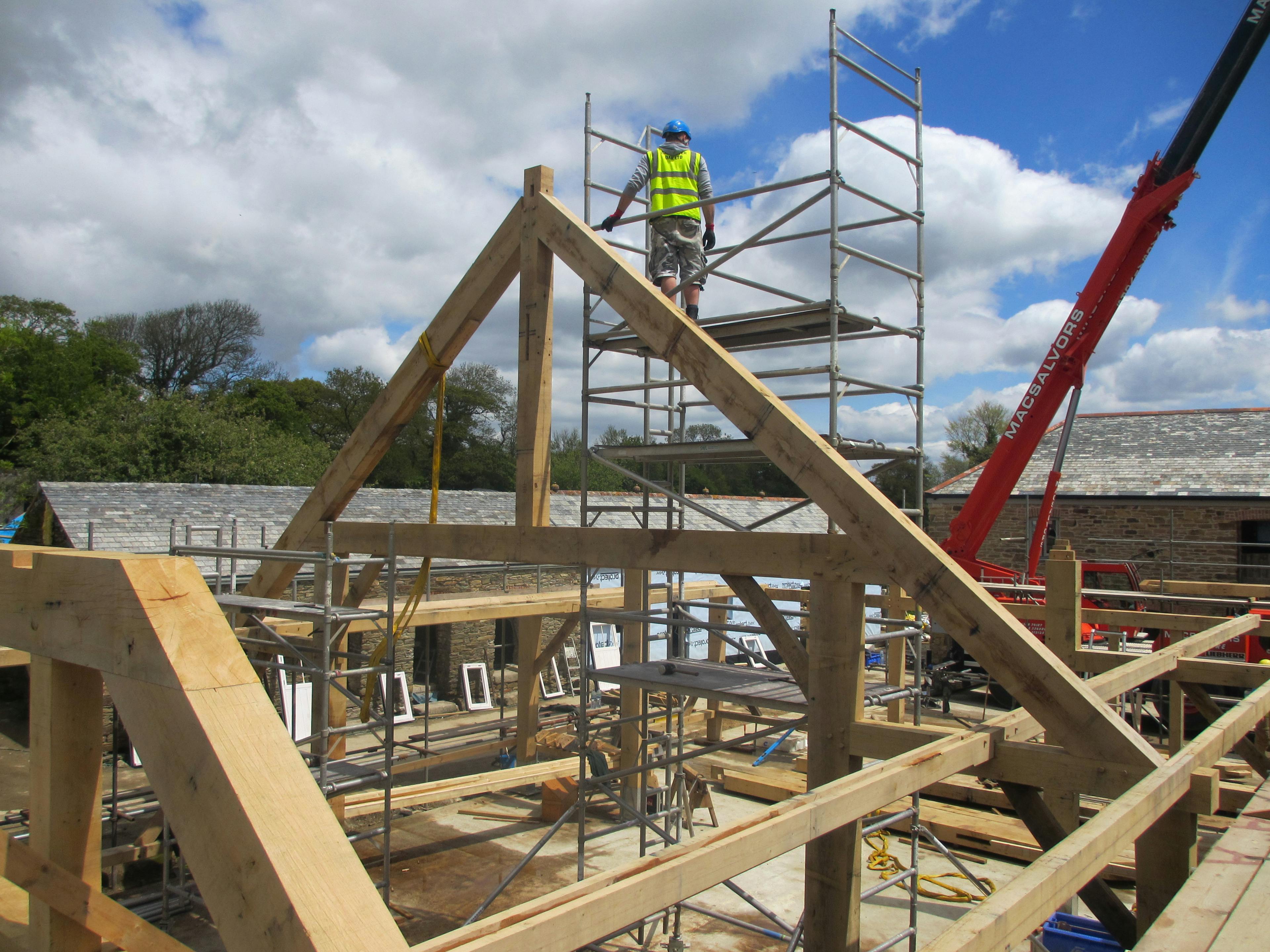 On a construction site the frame for an oak framed wedding barn is installed