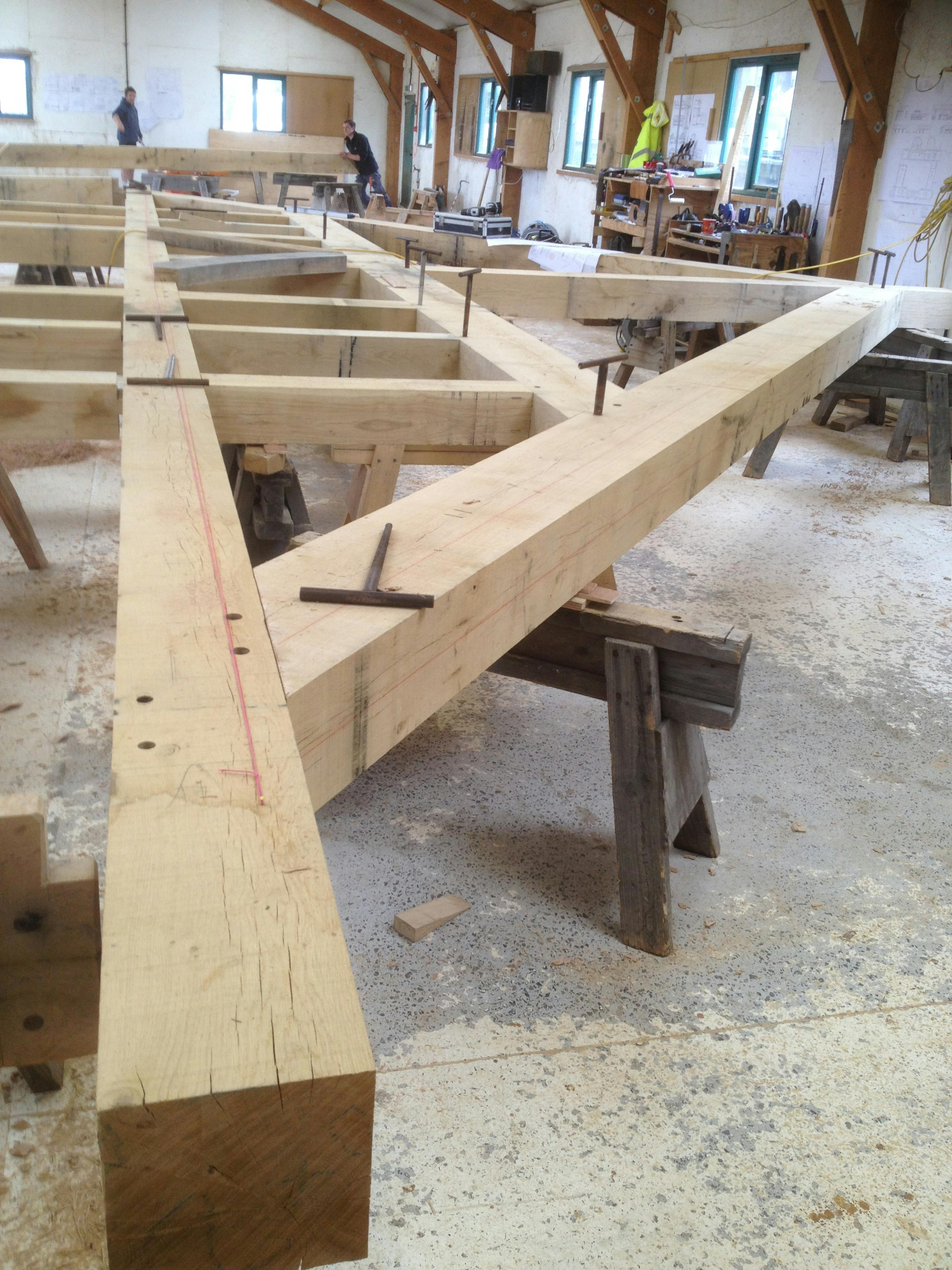 A large oak frame being manufactured by hand in a workshop