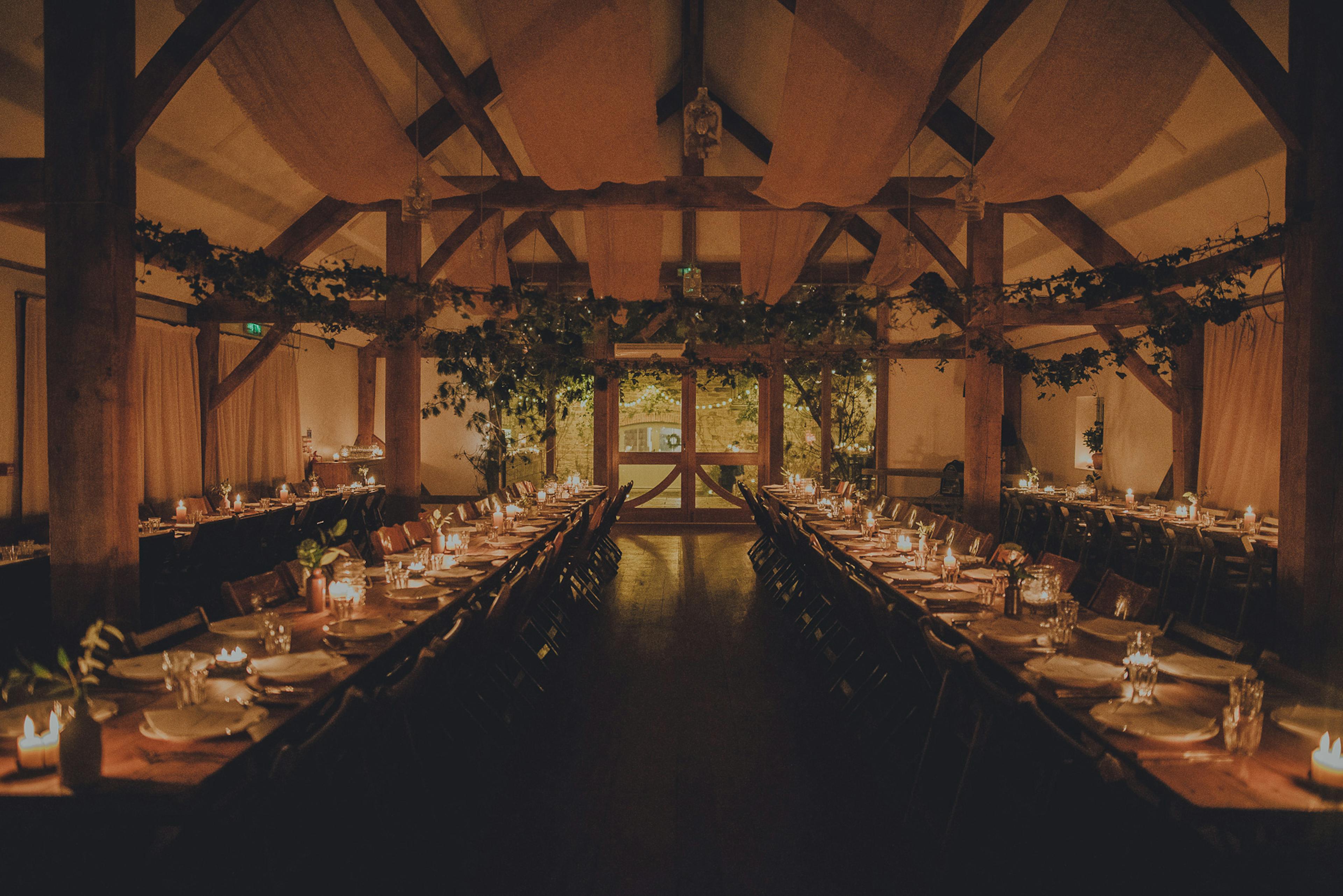Tables are set for a wedding in an oak framed wedding barn