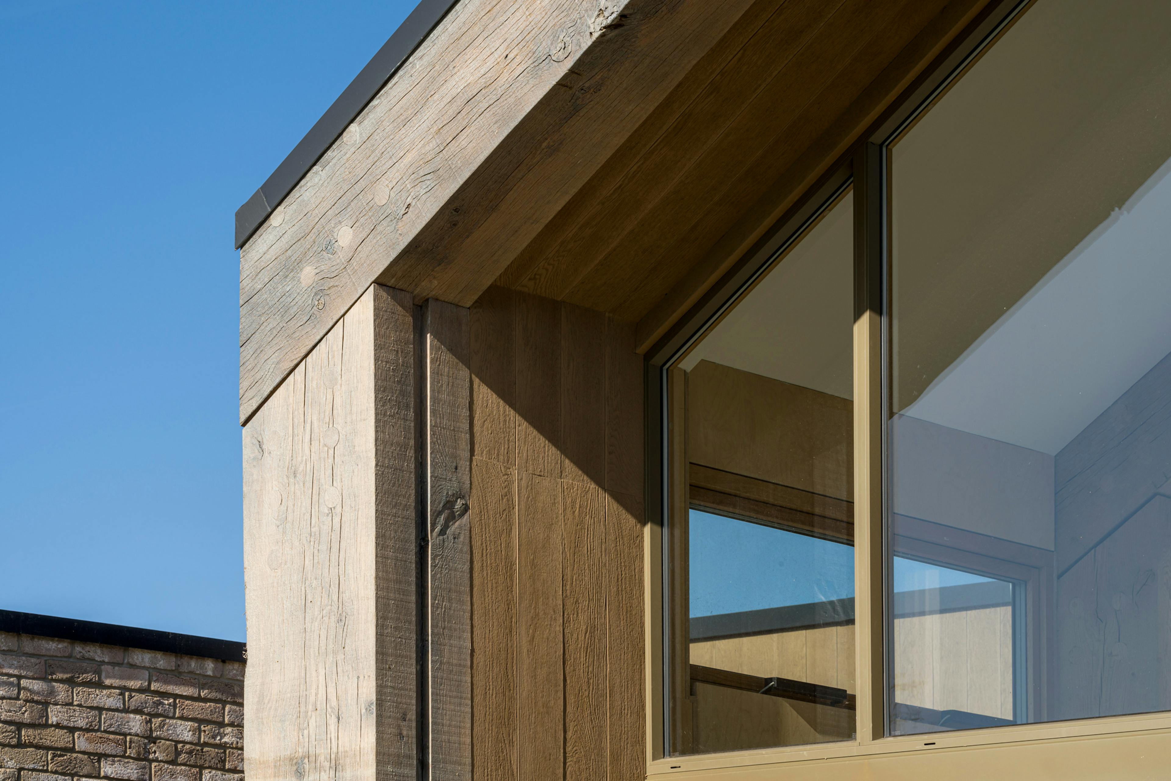 The window of a single storey brick children's hospital with a large oak framed atrium