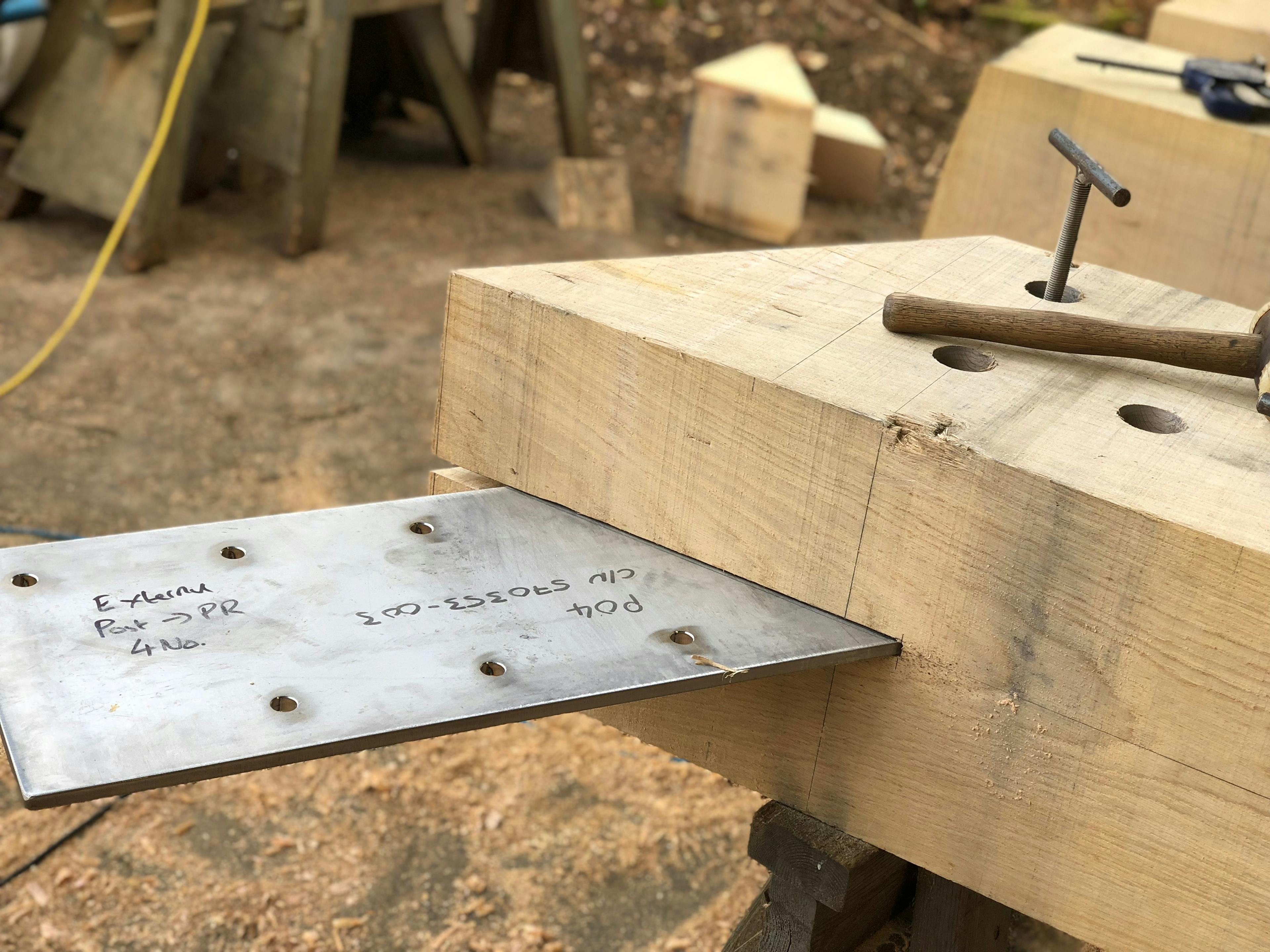 In a workshop an oak post has a steel connection coming out of it