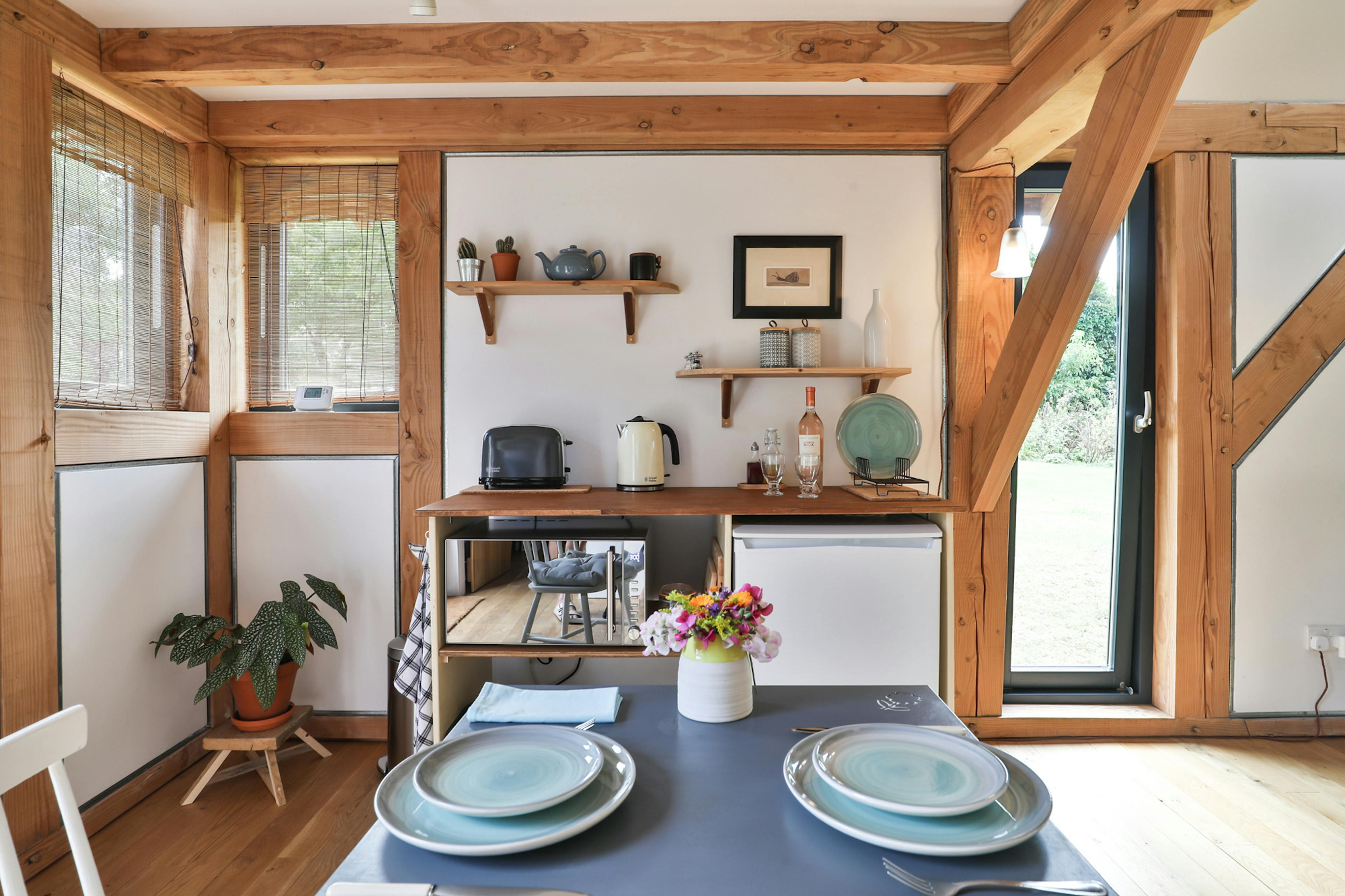 A laid dining table and chairs in a Douglas fir framed living room