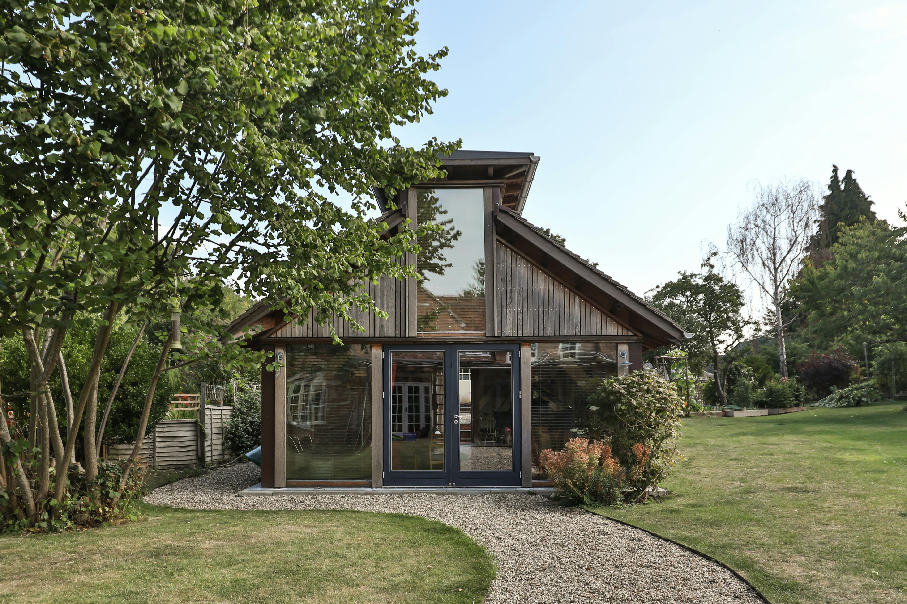 The back of a Douglas fir framed building with cedar cladding and oak shingles with a garden around it