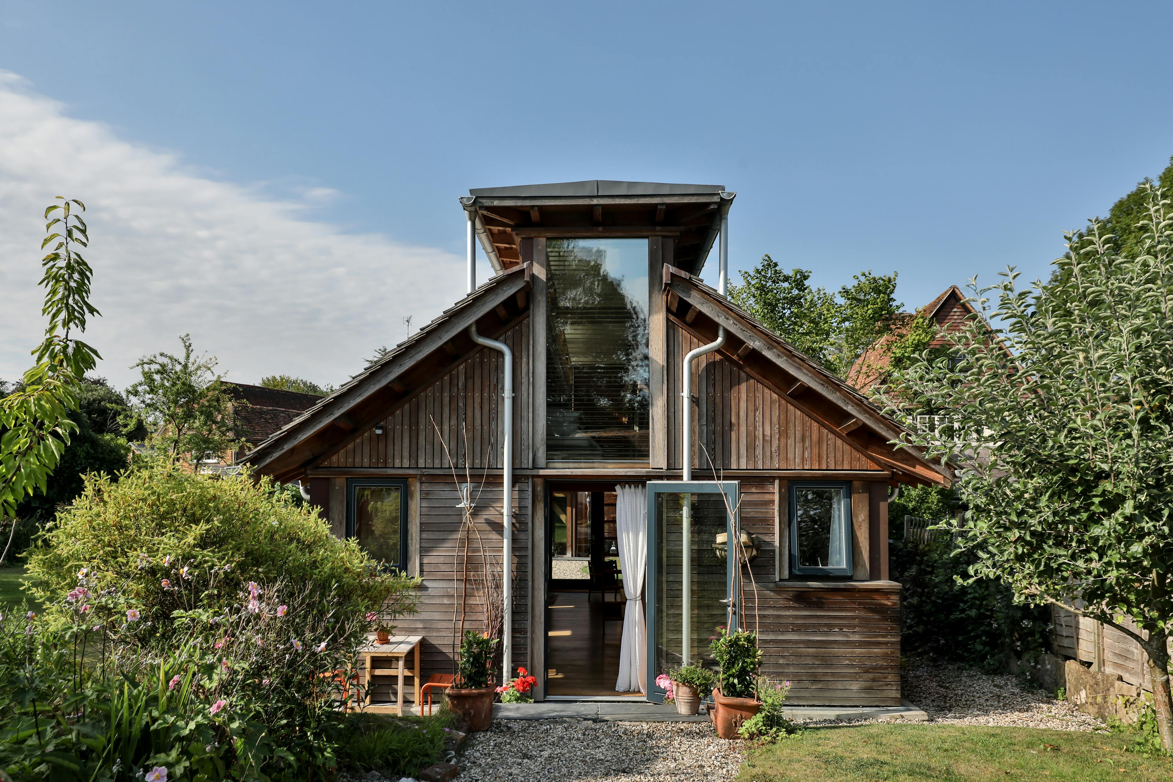 The front of a Douglas fir framed building with cedar cladding and oak shingles with a garden around it