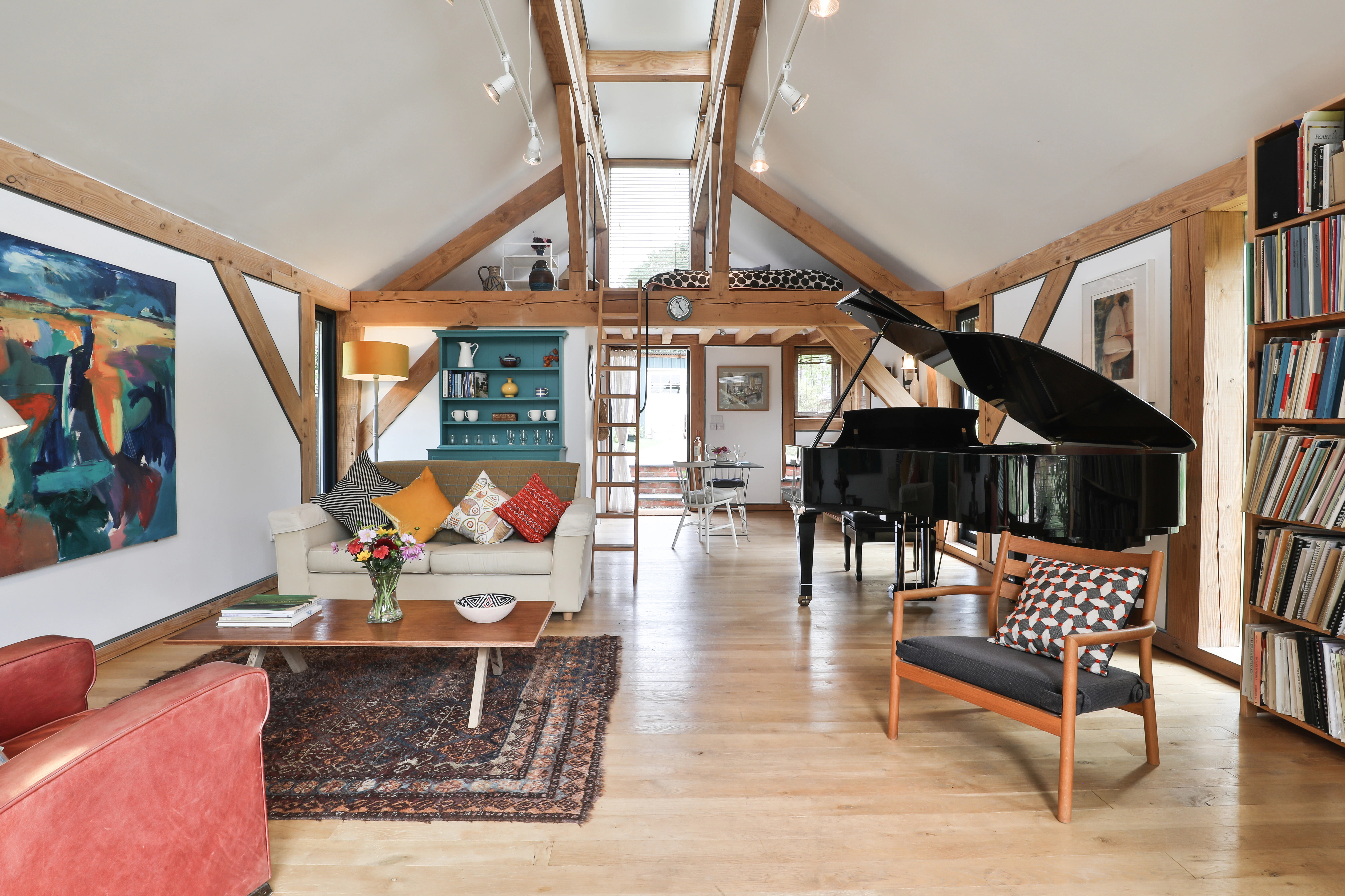 Sofas and a black grand piano in an open plan Douglas fir framed living room