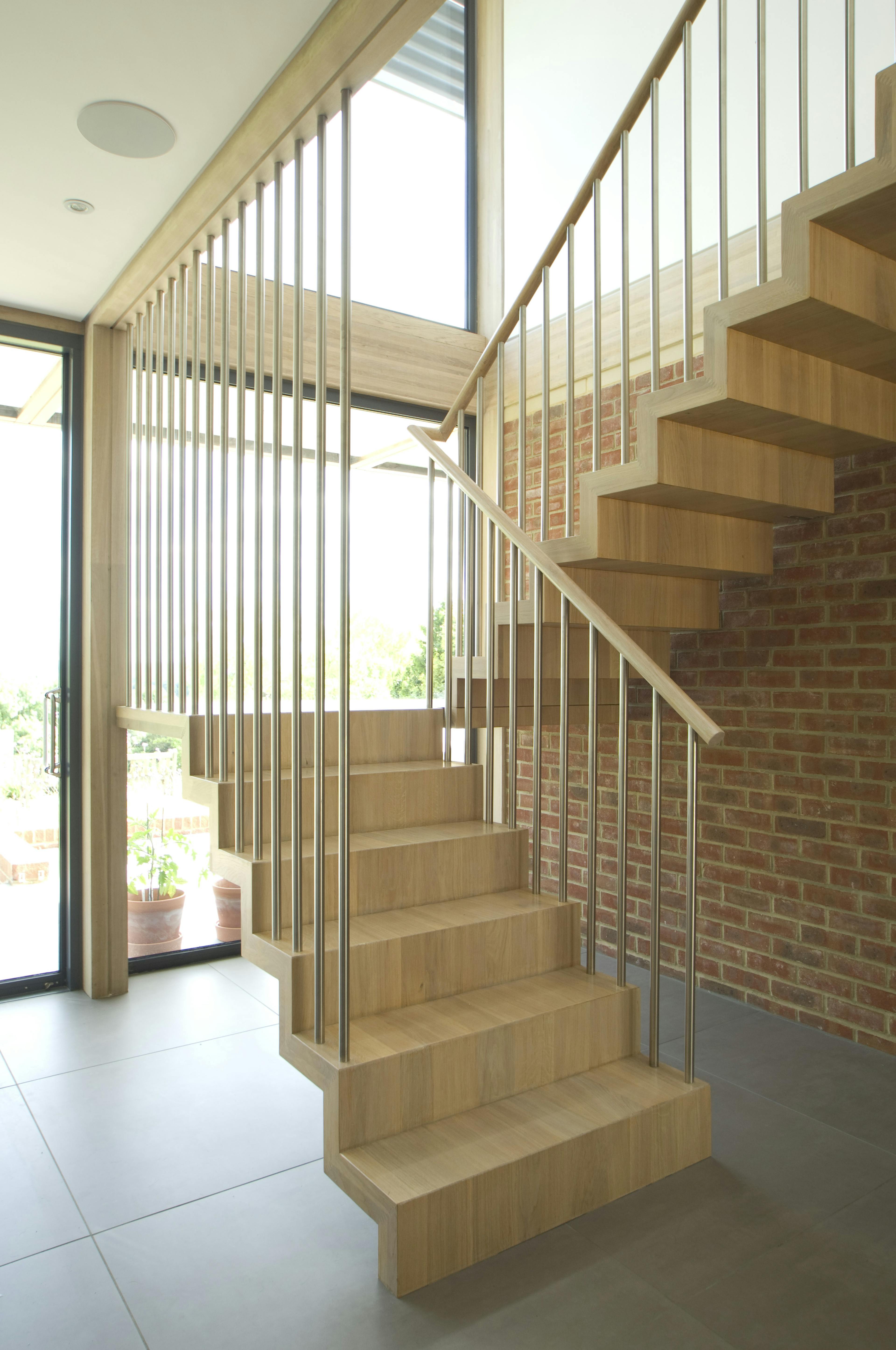 The wooden stairs and entranceway within an oak glulam framed house