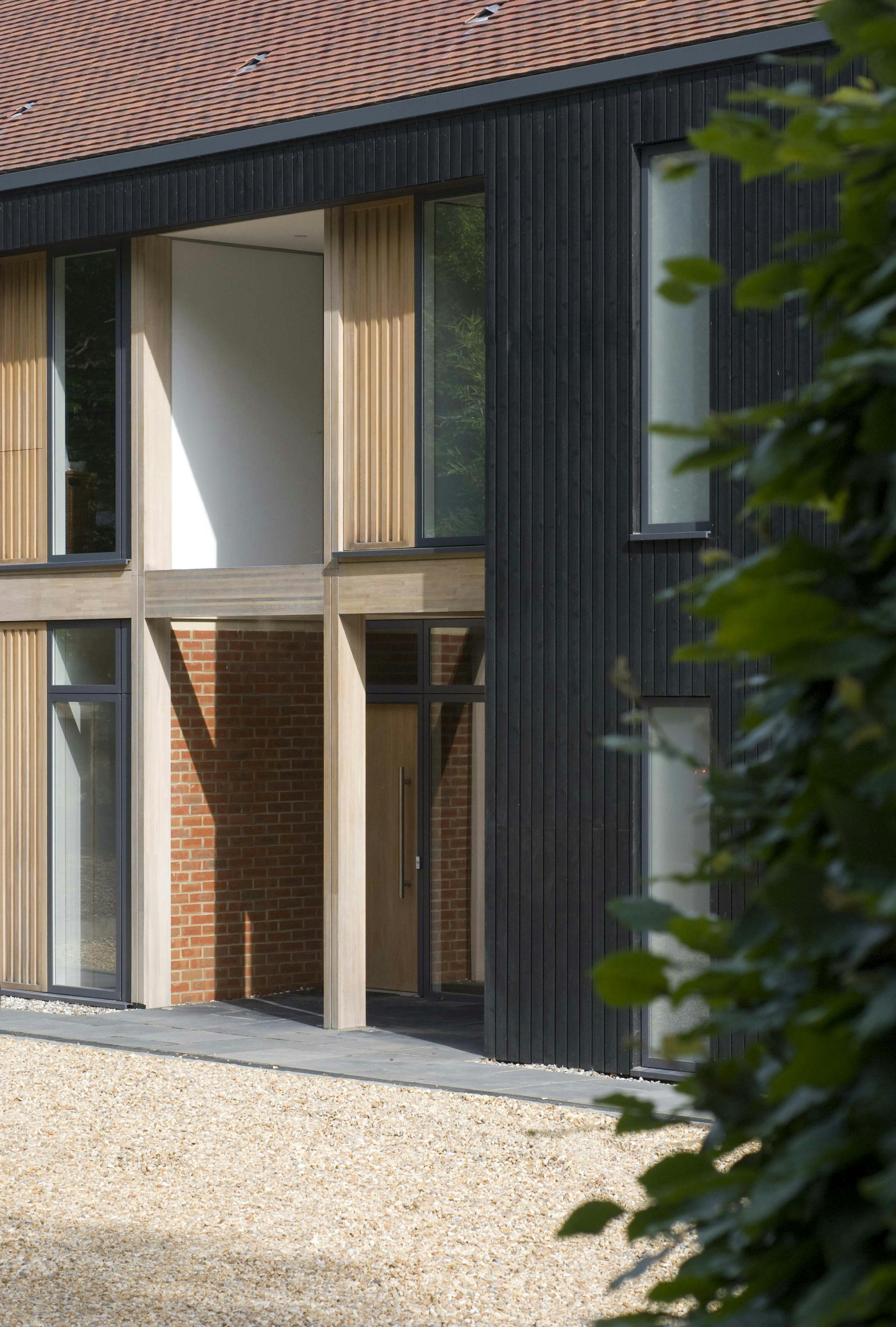 The front of an oak glulam house with black cladding