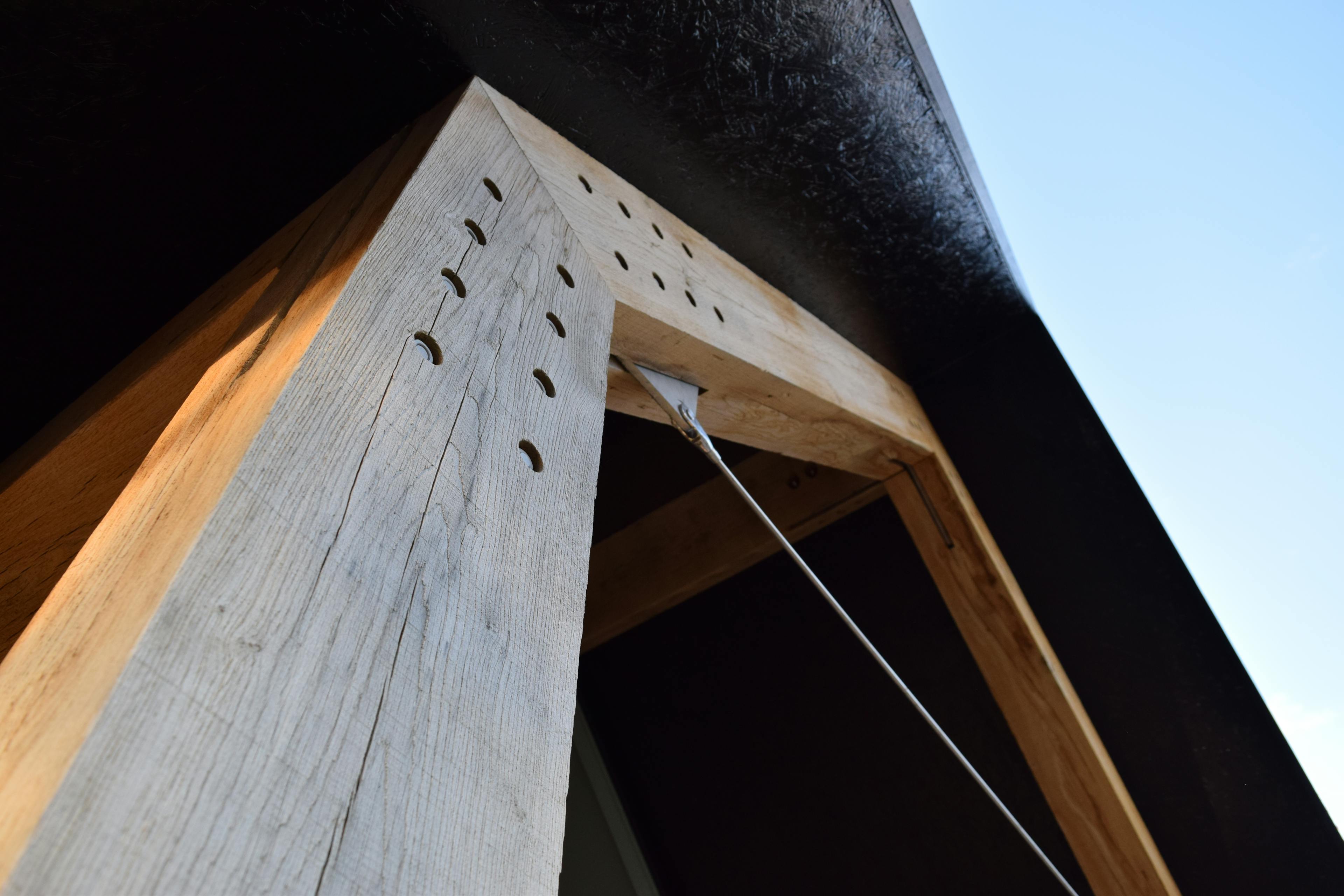 A large oak post with steel connections, bolts and tie rods