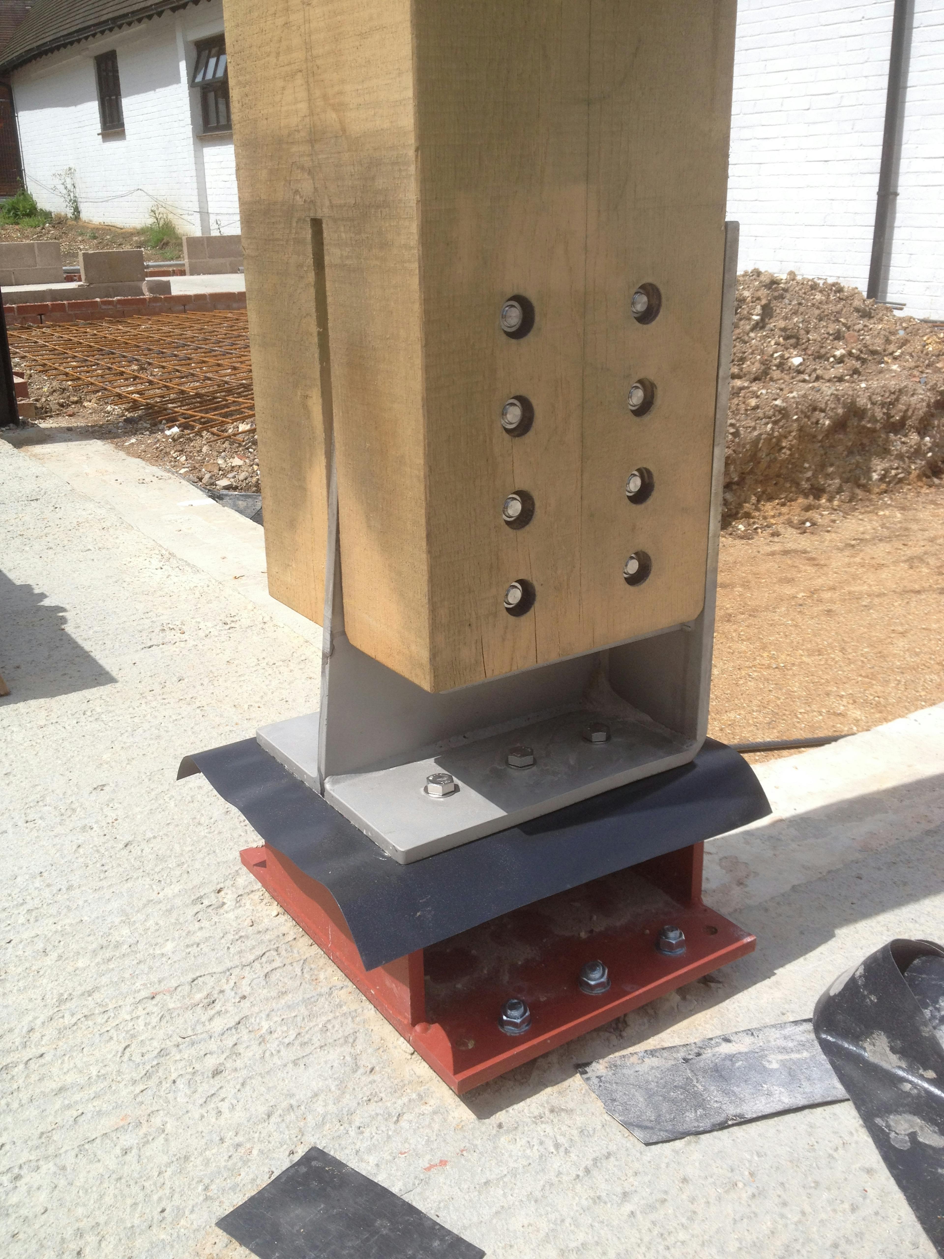 A steel foot post connected to the bottom of an oak post with steel bolts to hold it in place