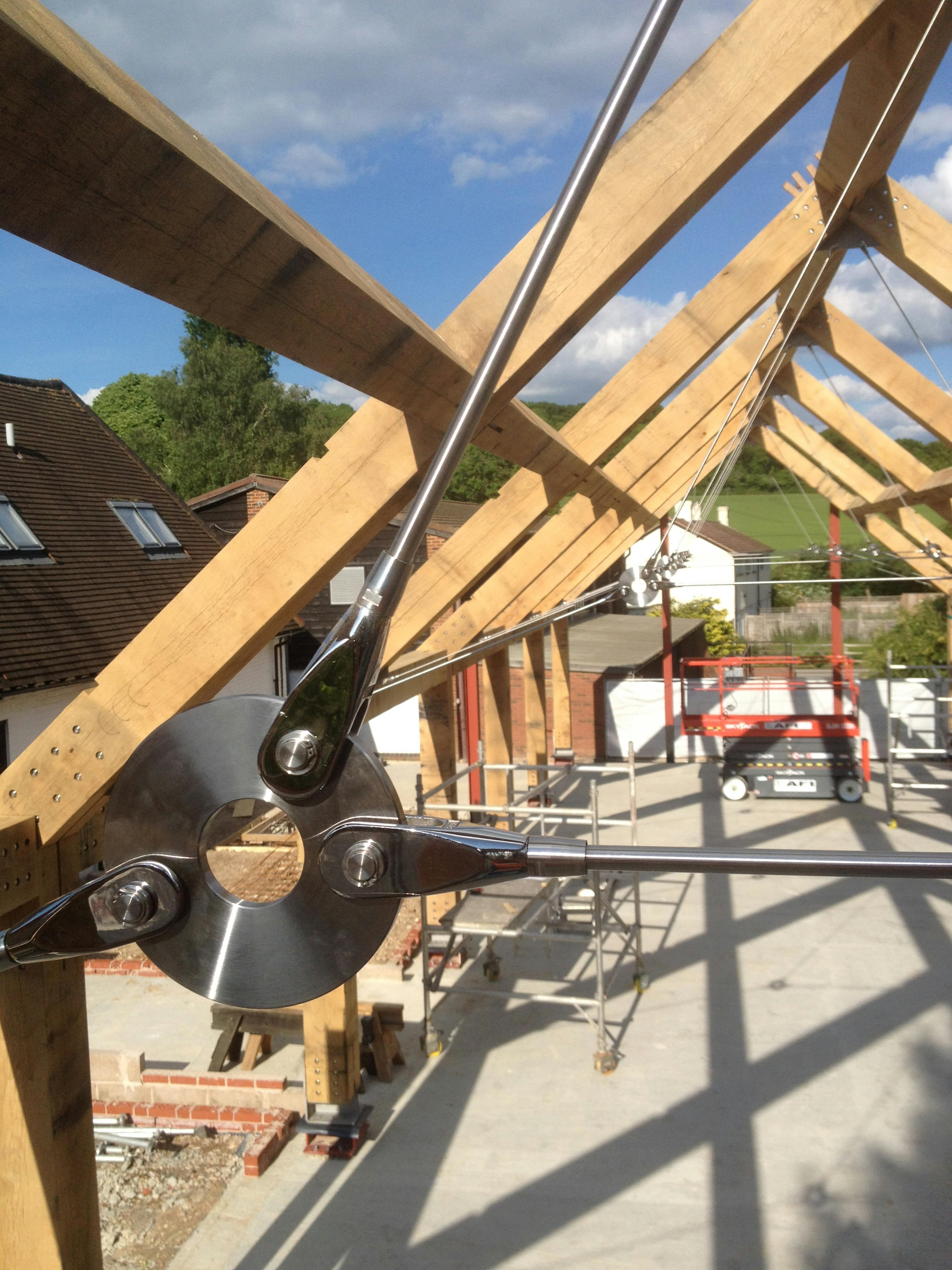 Installation of an oak and steel frame with a steel tie rod for a large building on a construction site