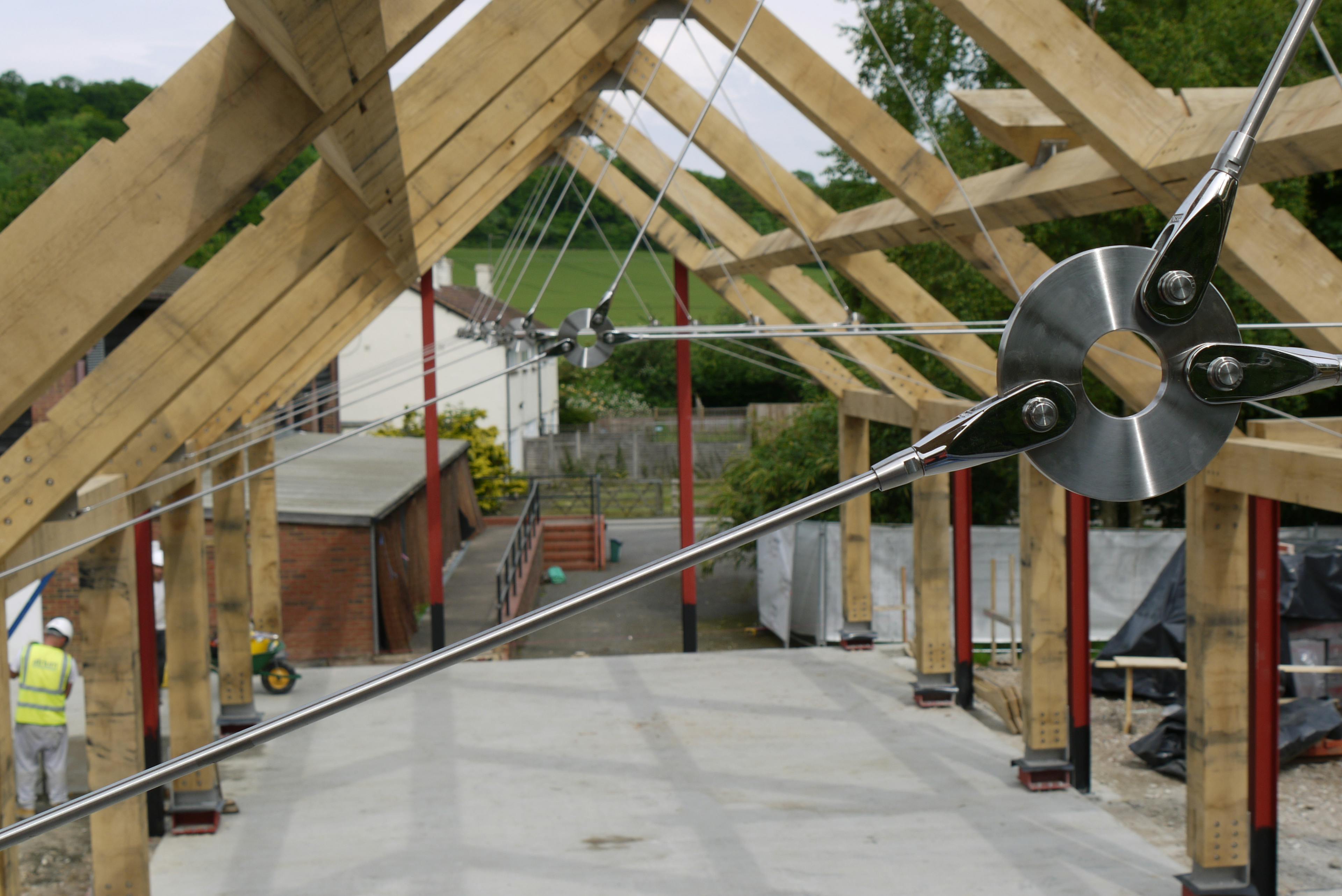 Installation of an oak and steel frame with a steel tie rod for a large building on a construction site
