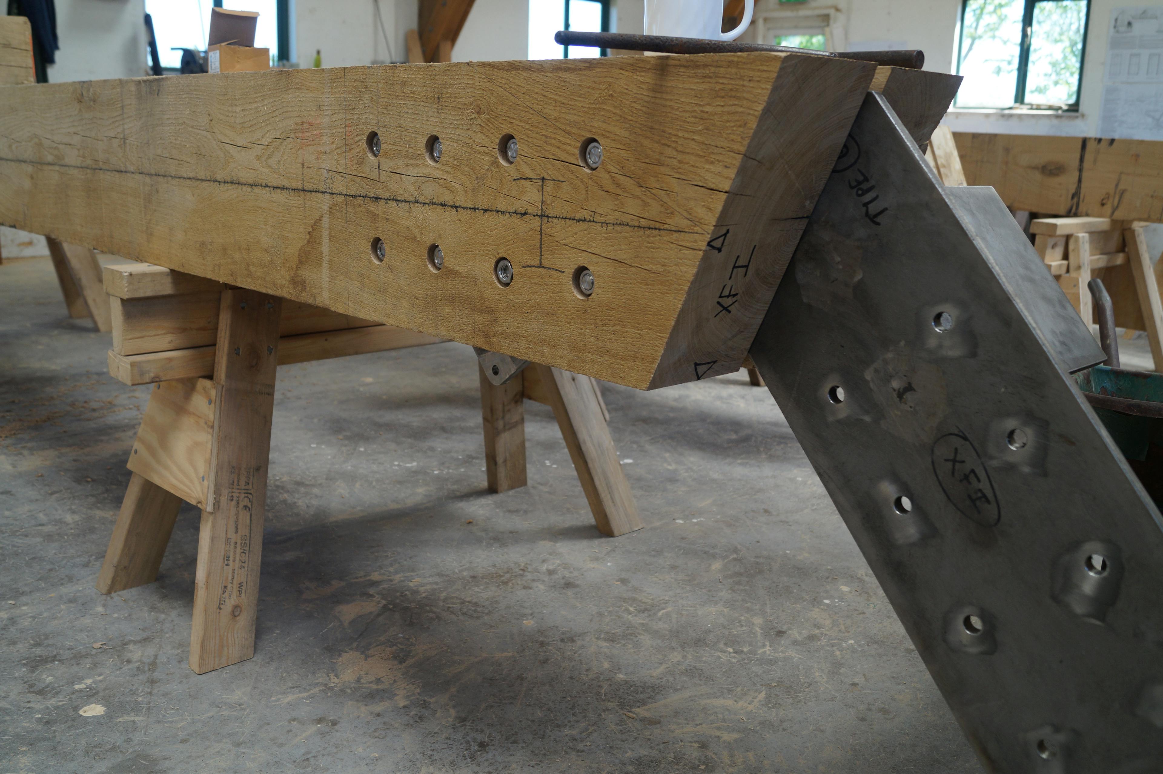 A steel connection flitch plate connected to an oak post in a workshop