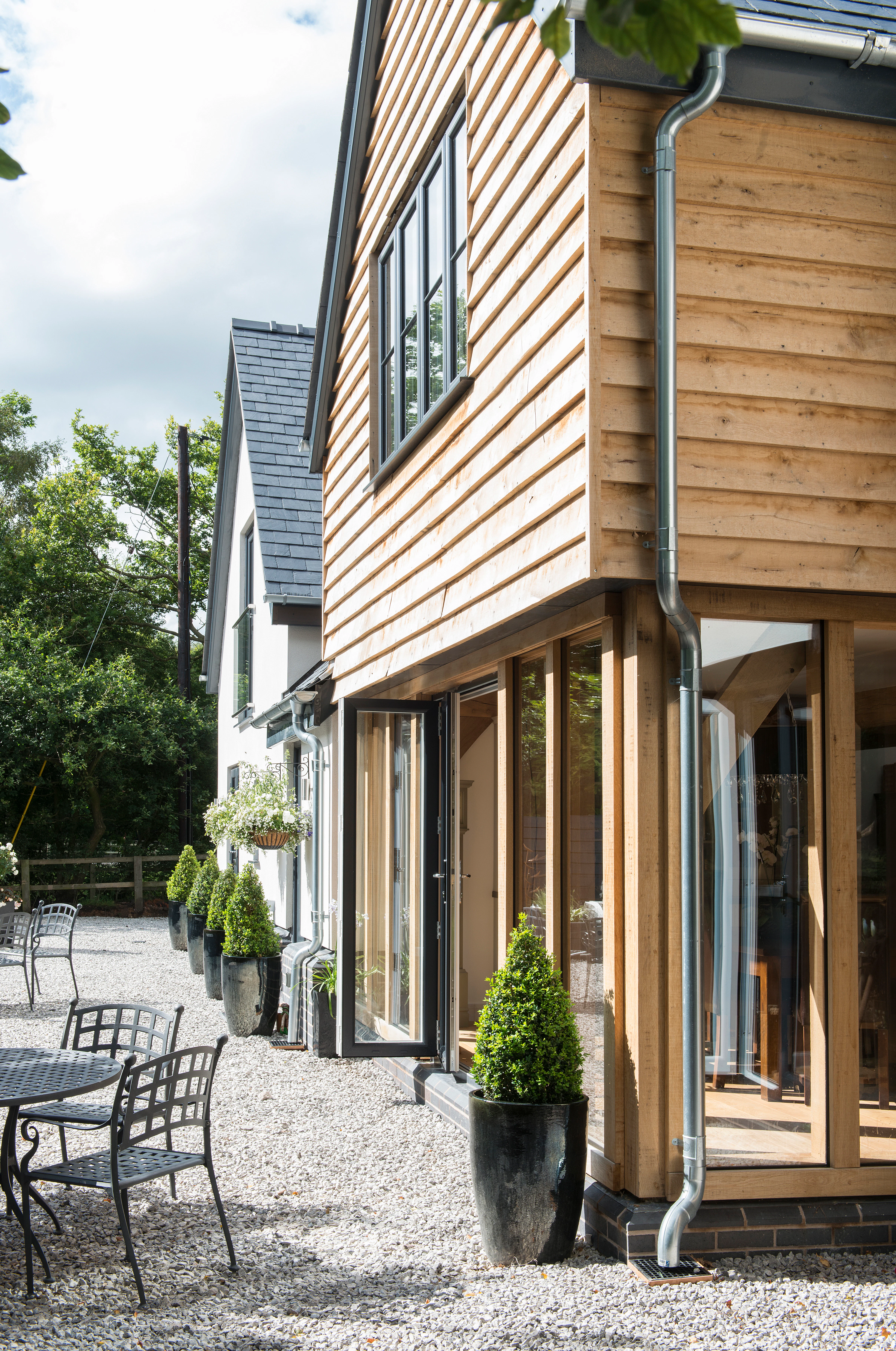 A timber clad oak framed home with outdoor seating