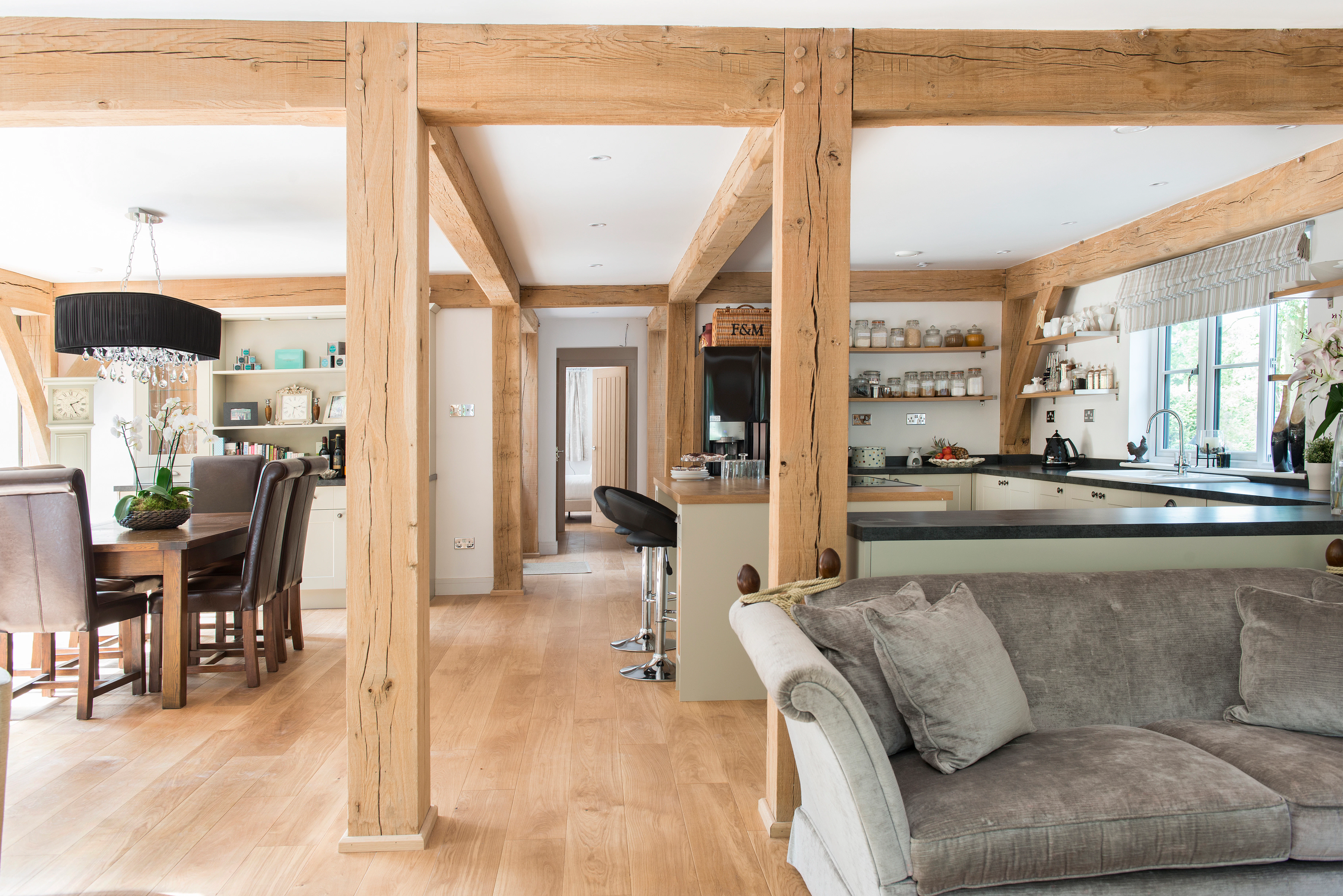 An open plan sitting room, kitchen and dining area of an oak framed home