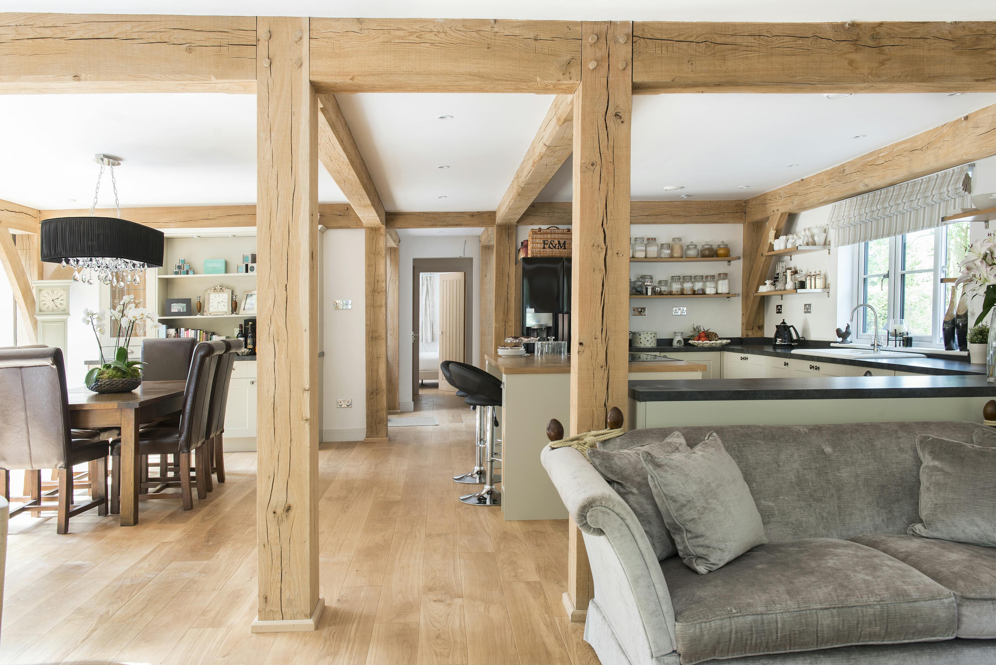 An open plan sitting room, kitchen and dining area of an oak framed home