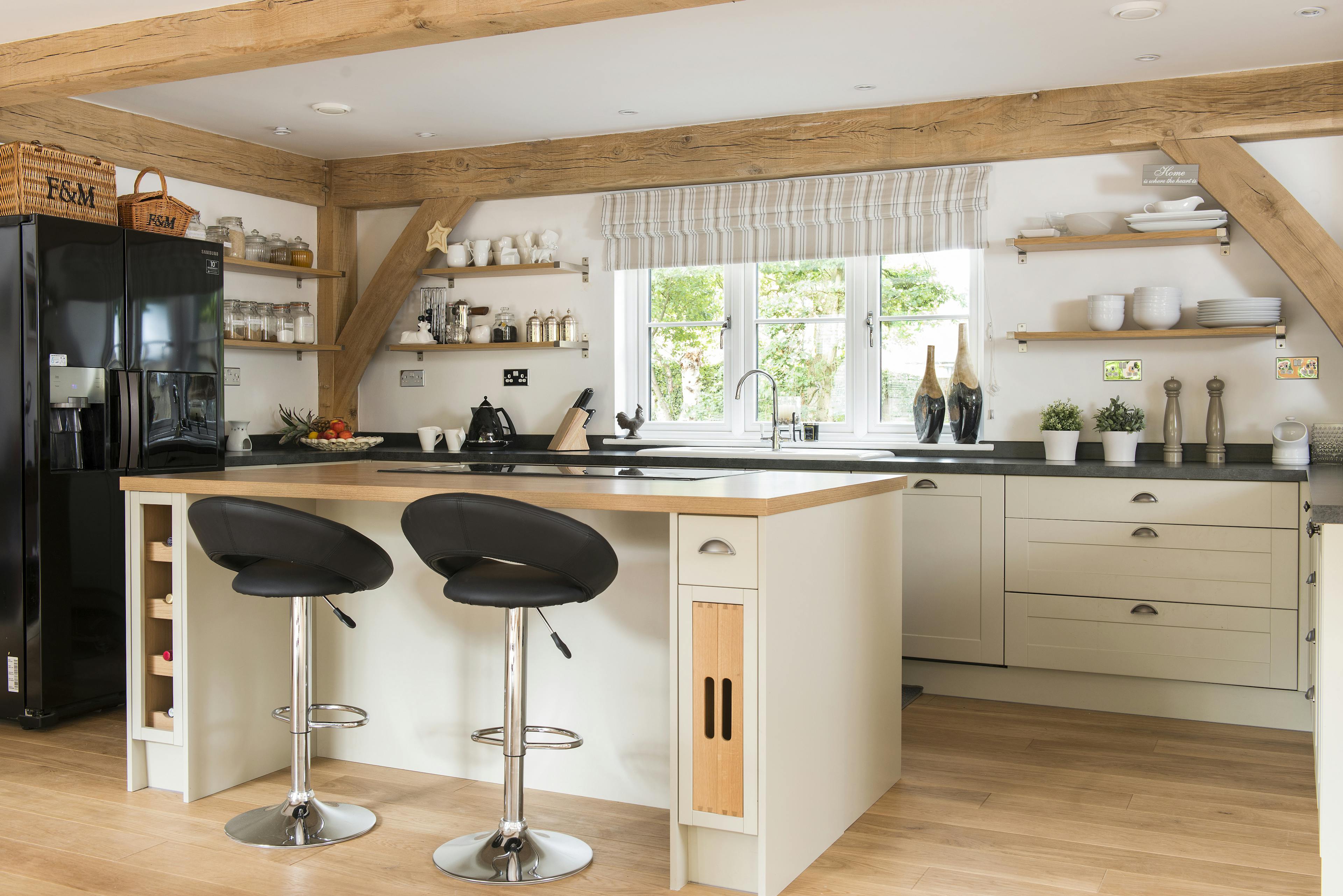 A large kitchen island with a breakfast bar in an oak framed home