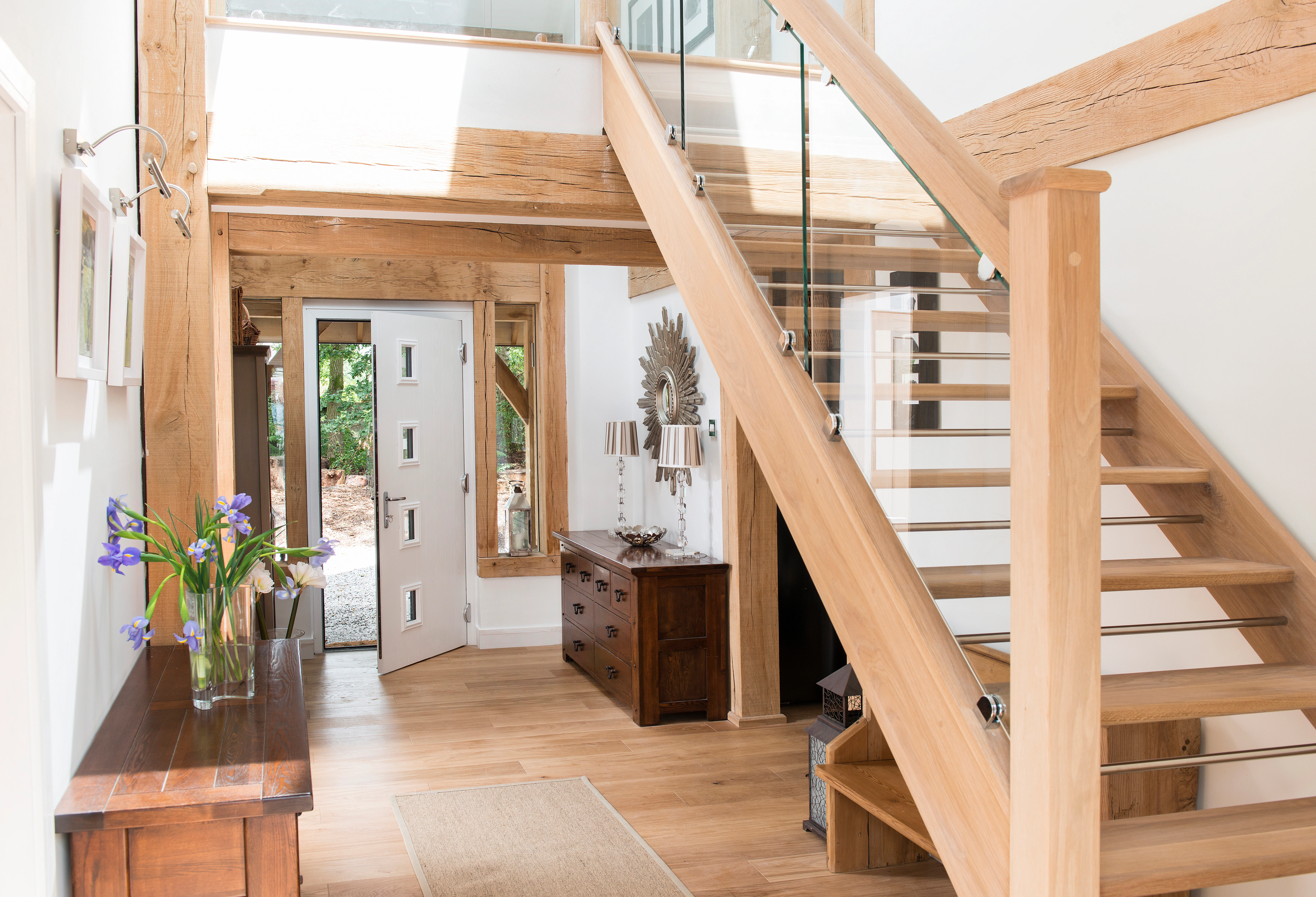 A wooden staircase in an entrance of an oak framed home