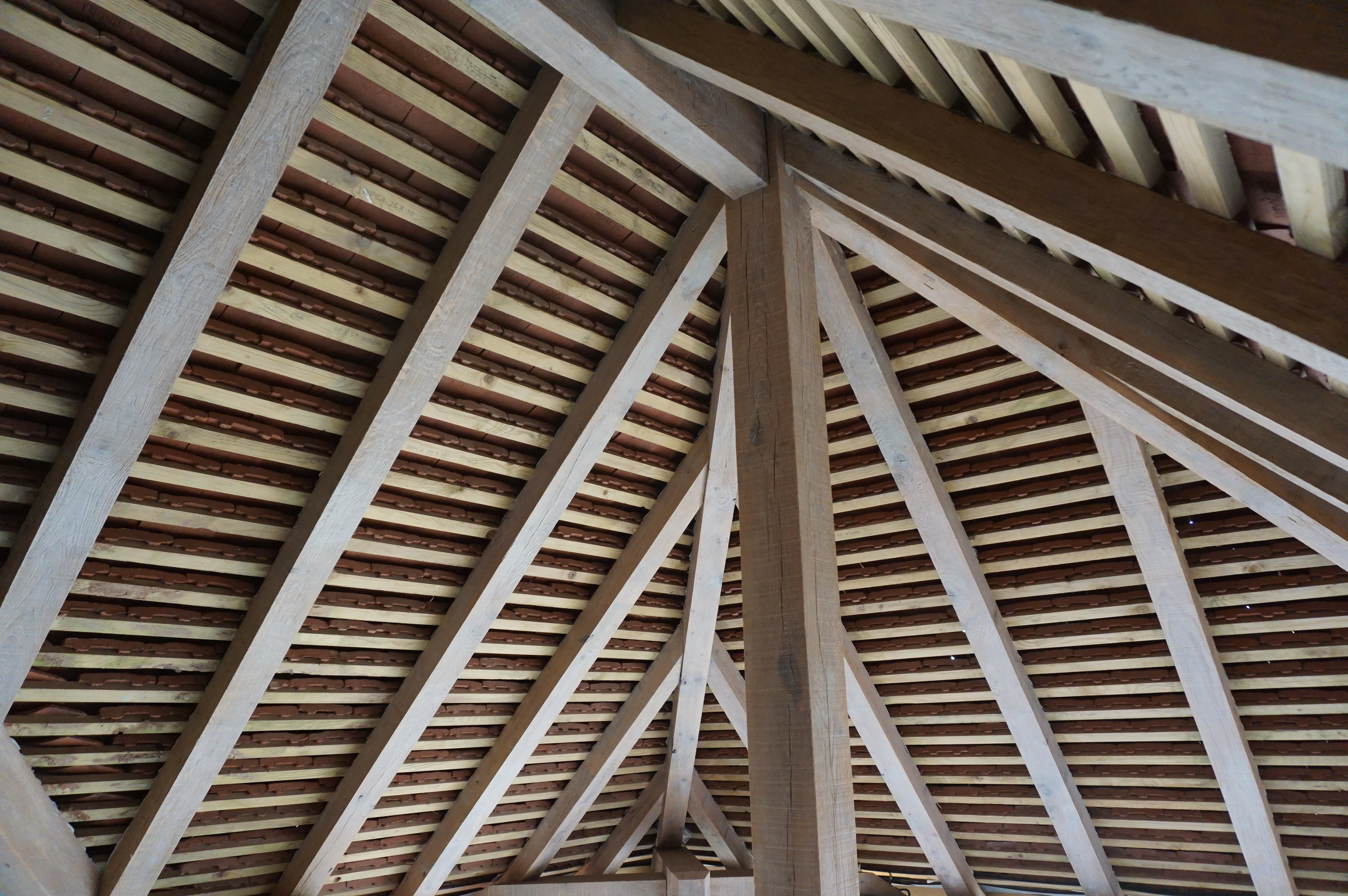 The underneath of an oak framed roof showing the frame with roof boarding