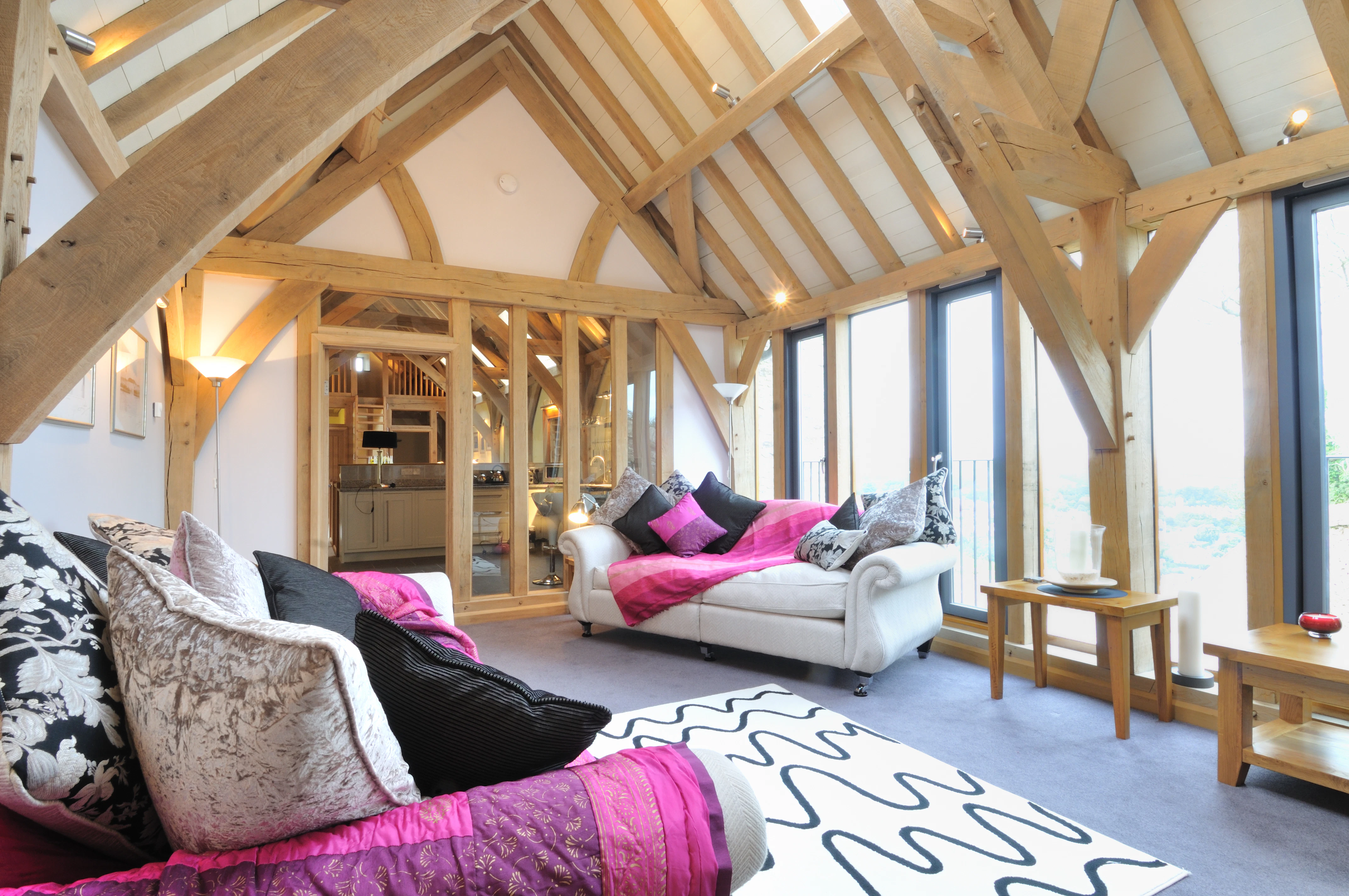 An oak framed sitting room with sofas and wooden side tables
