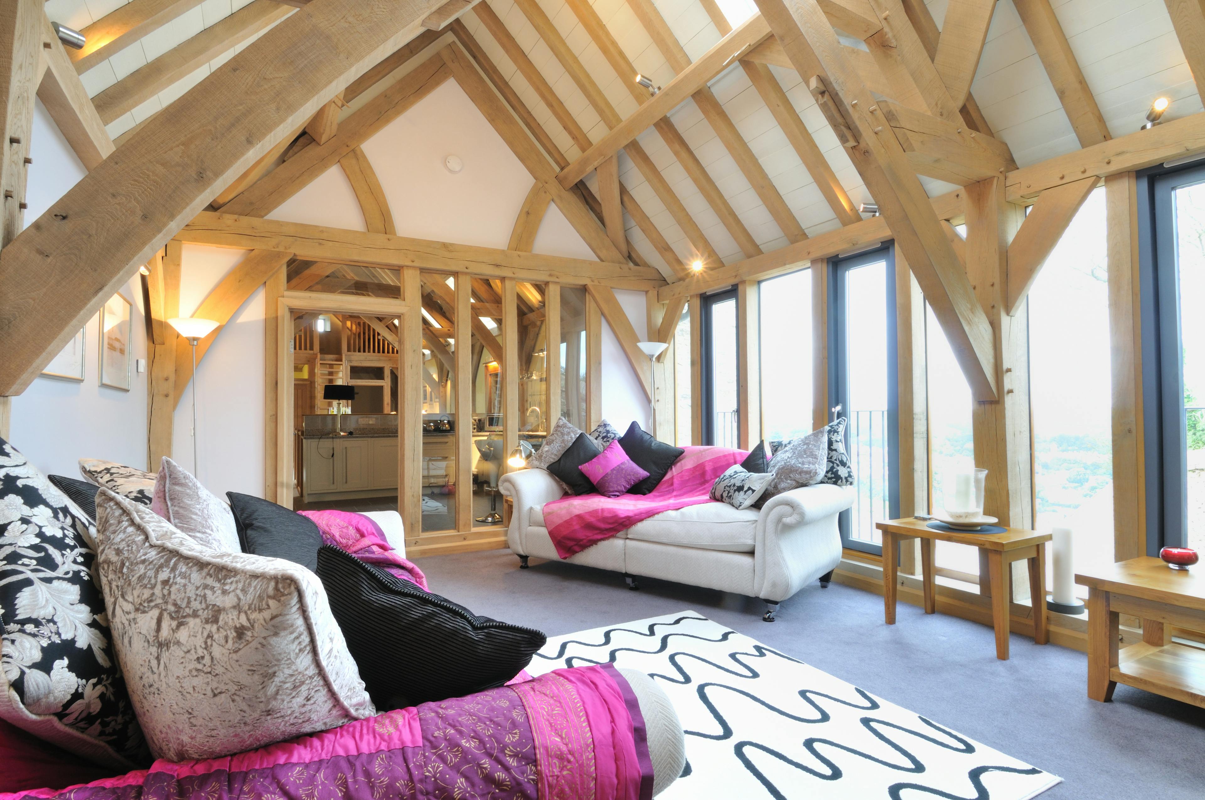 An oak framed sitting room with sofas and wooden side tables