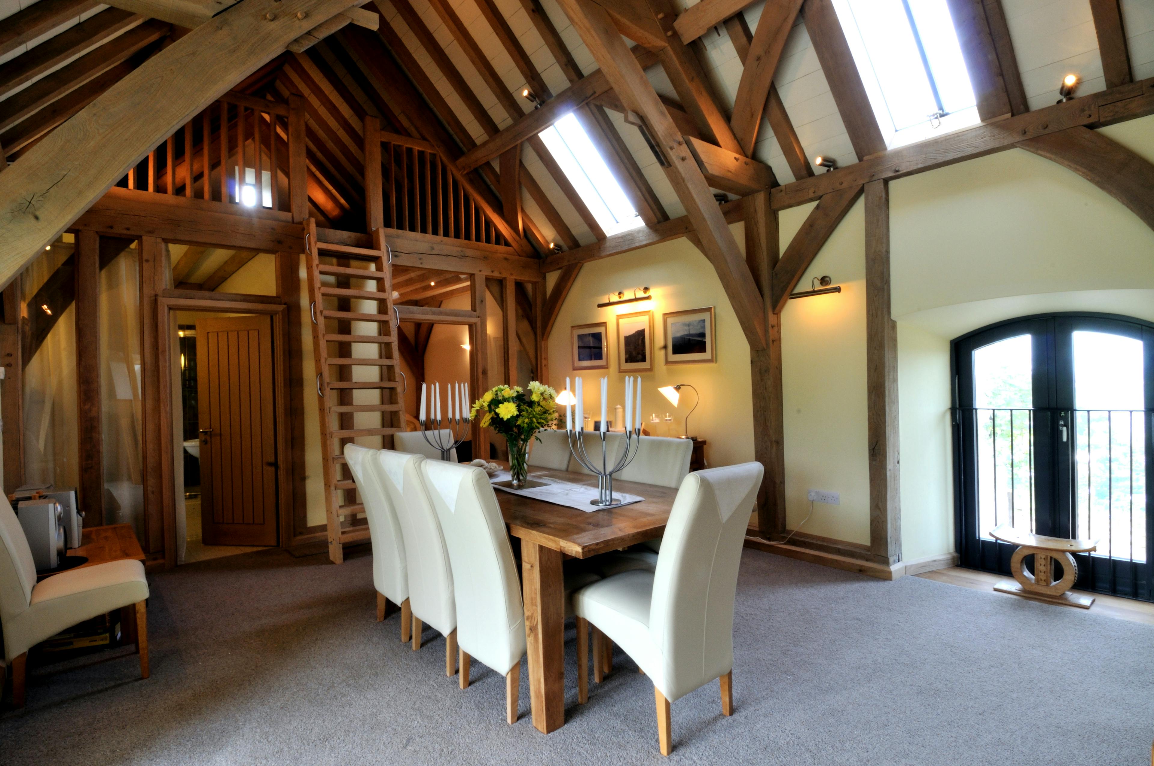 An oak framed dining area with a ladder to a mezzanine area