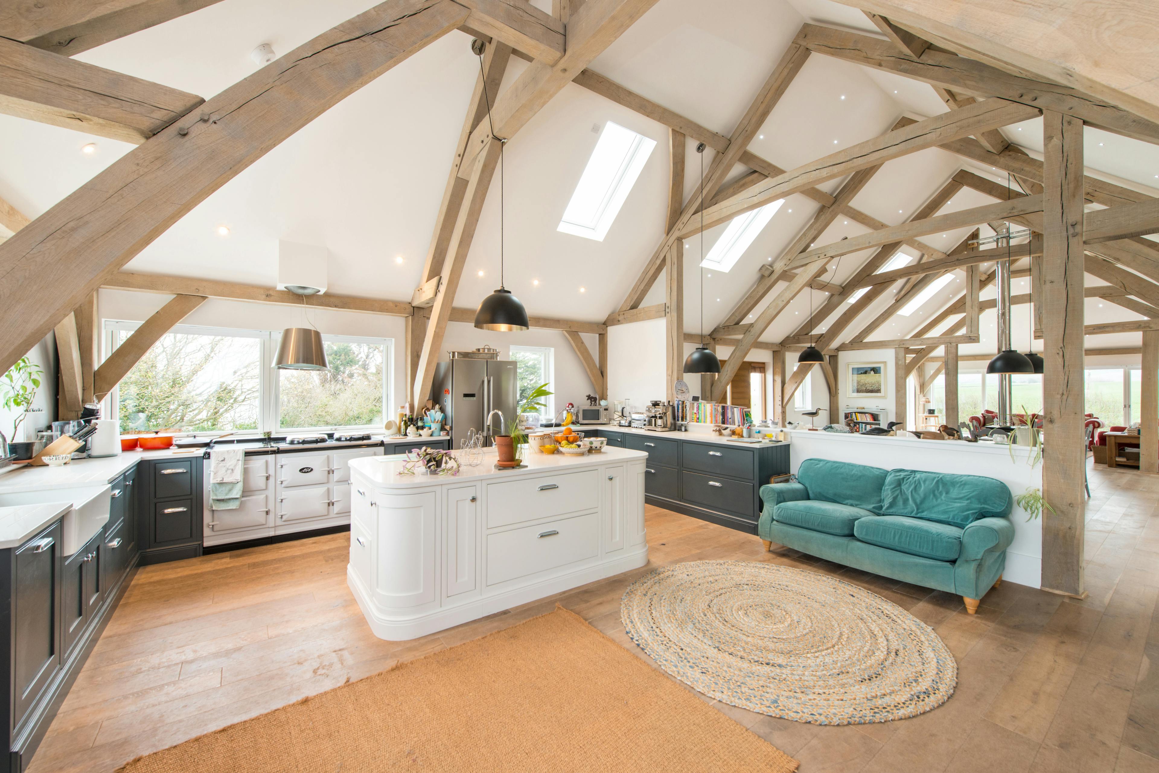 A vaulted oak framed open plan kitchen and living room with a white painted island