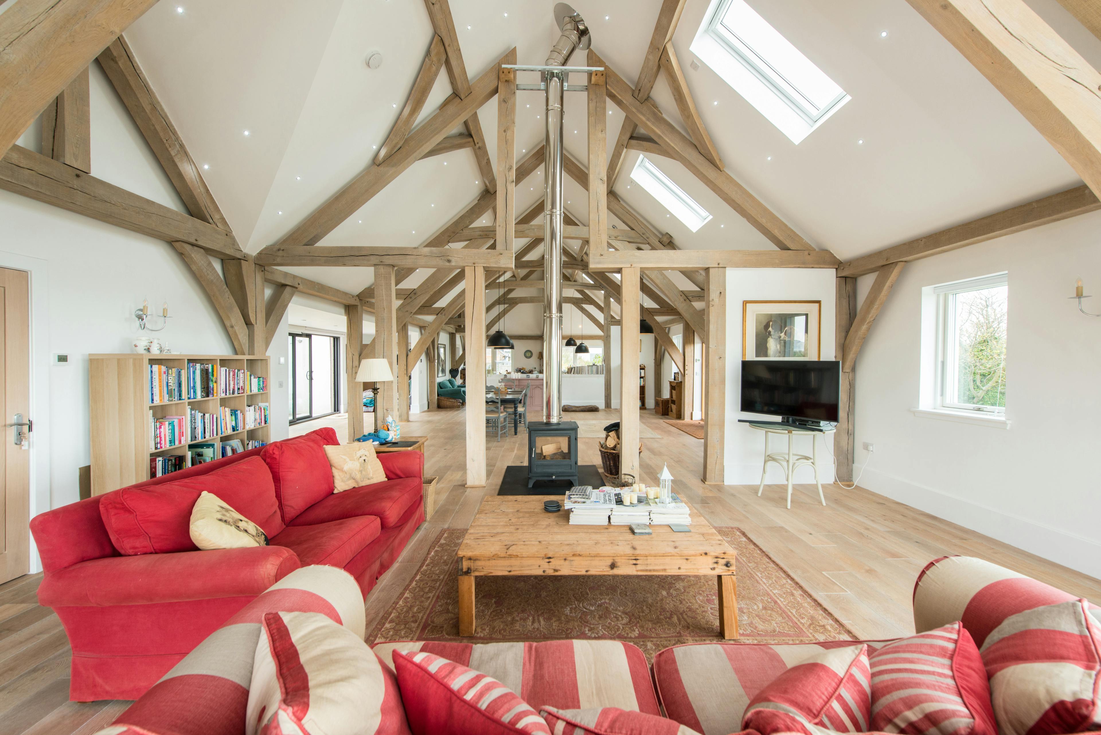 A vaulted oak framed open plan sitting room with a log burner