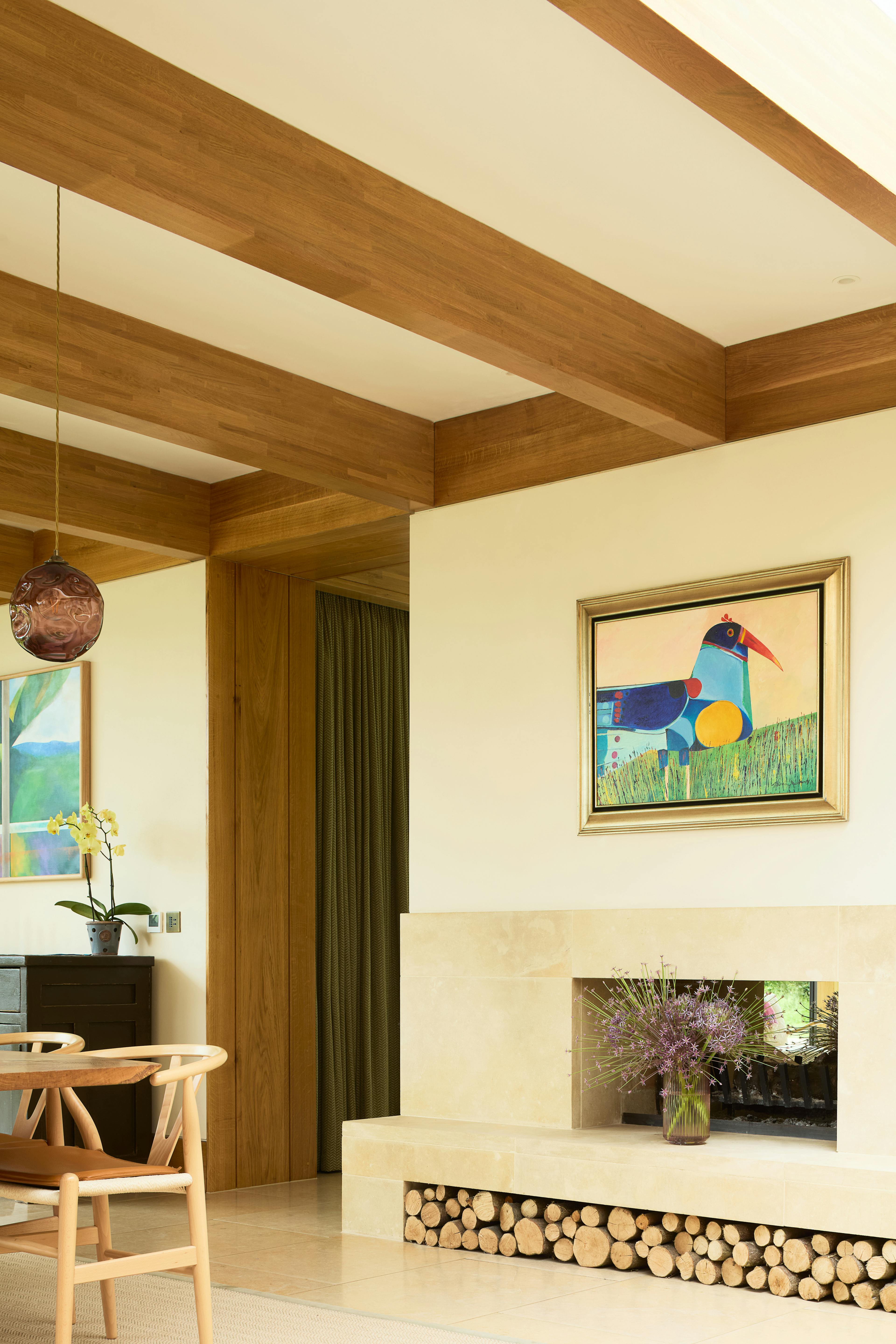 The dining area and fireplace of an oak glulam extension to a listed manor house