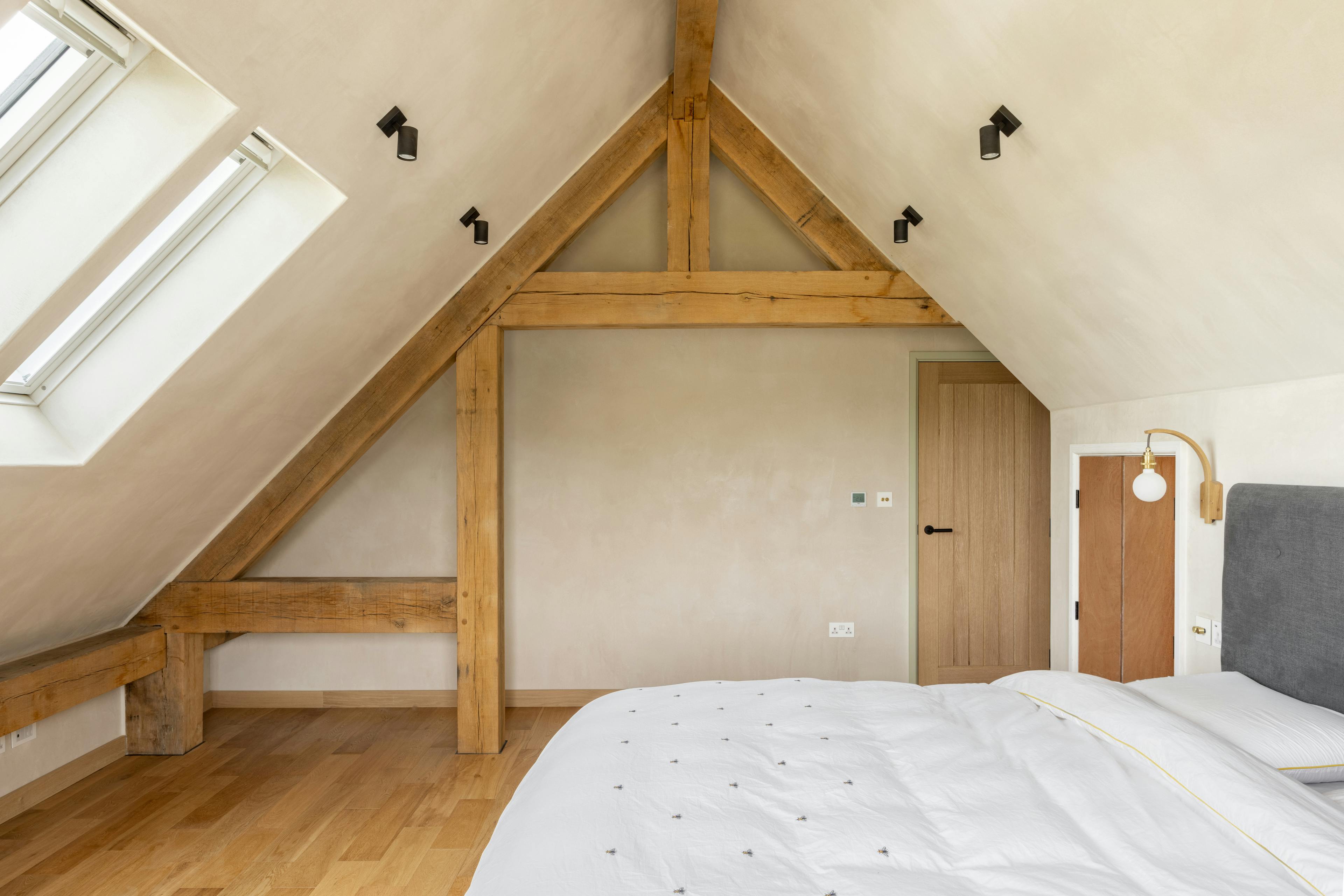 An oak framed bedroom in a roof space with sloping ceilings