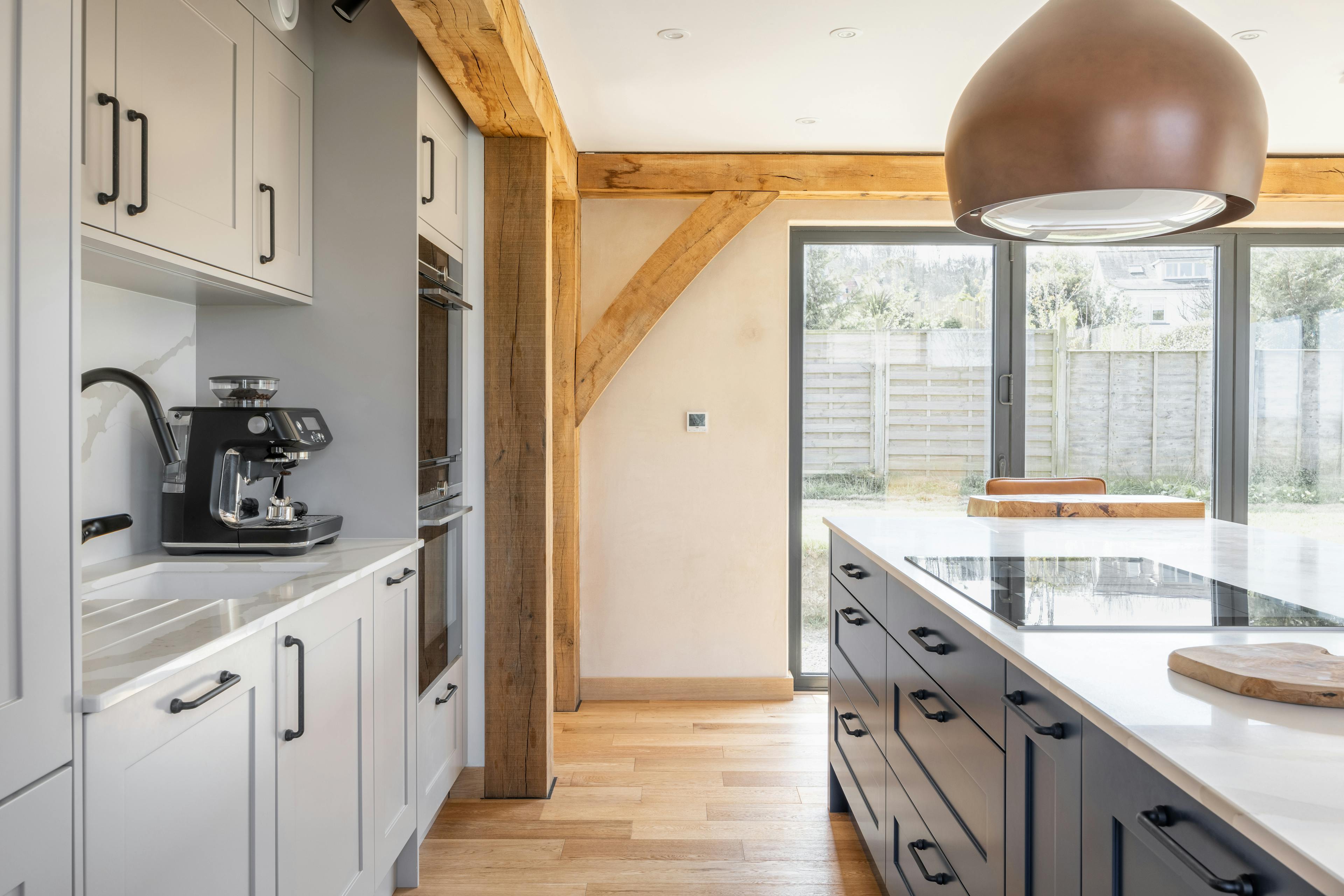 An oak framed kitchen with a blue painted island