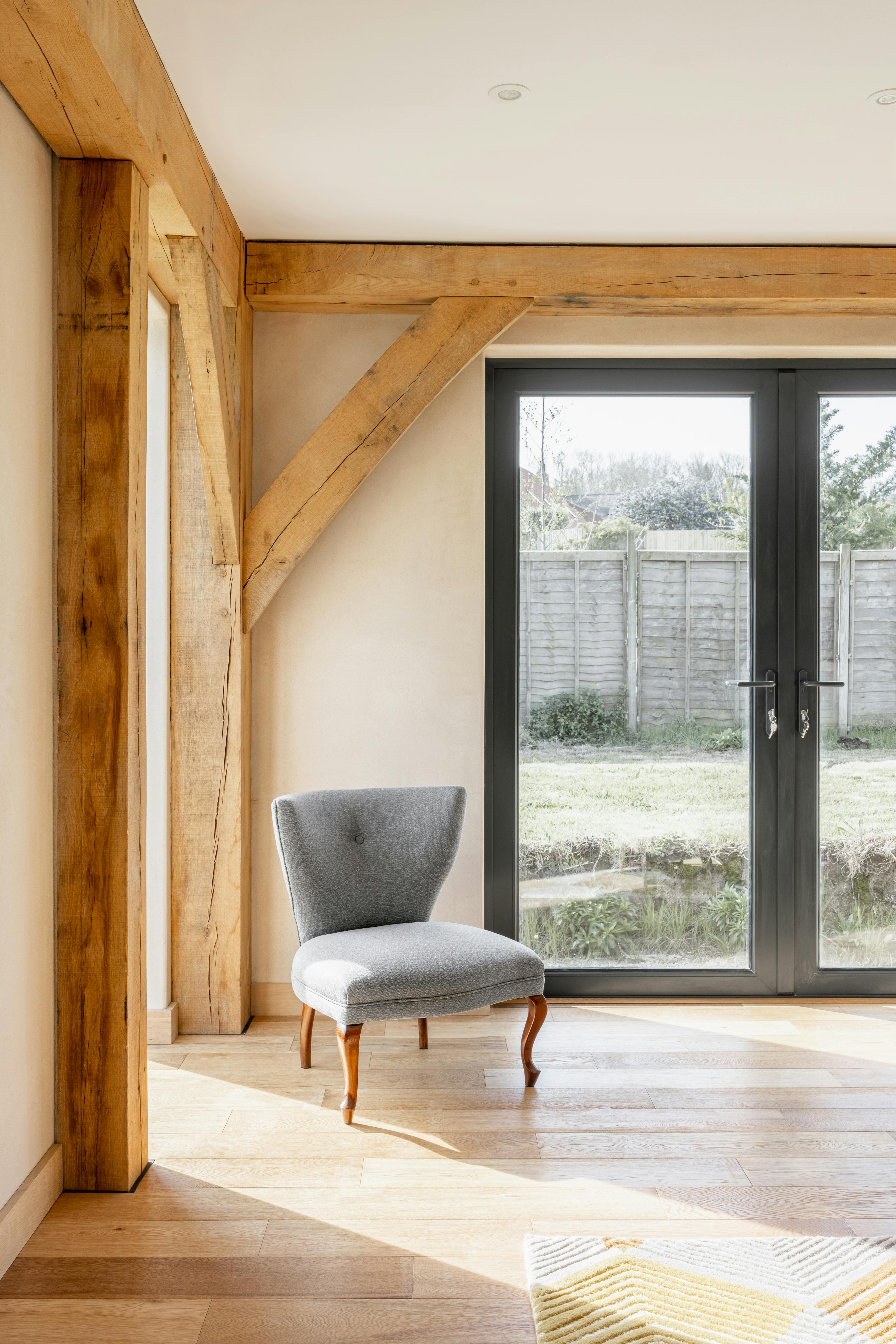 The corner of an oak framed living room with double doors into a garden