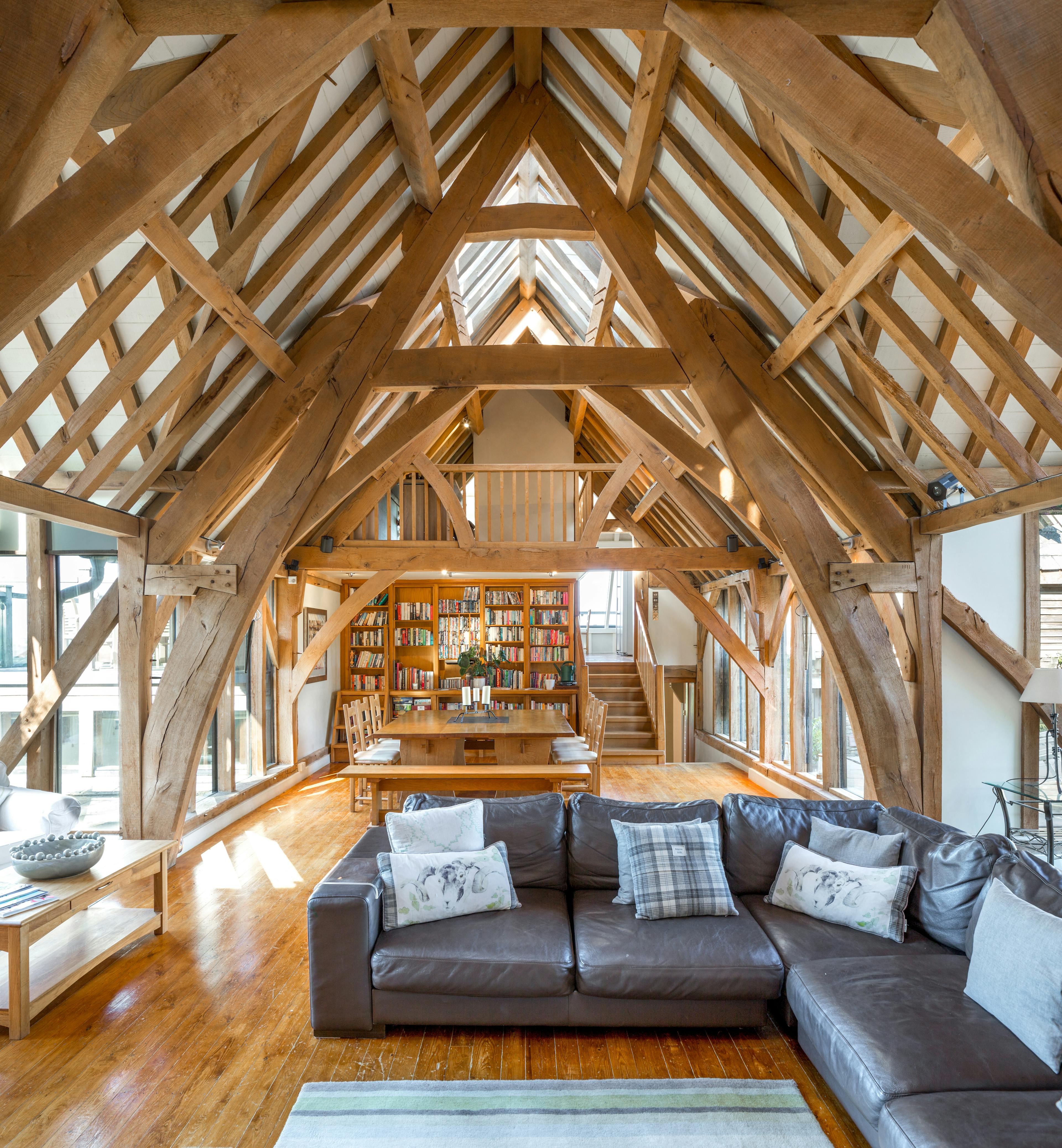 A large living sitting room with an oak frame cruck truss vaulted ceiling