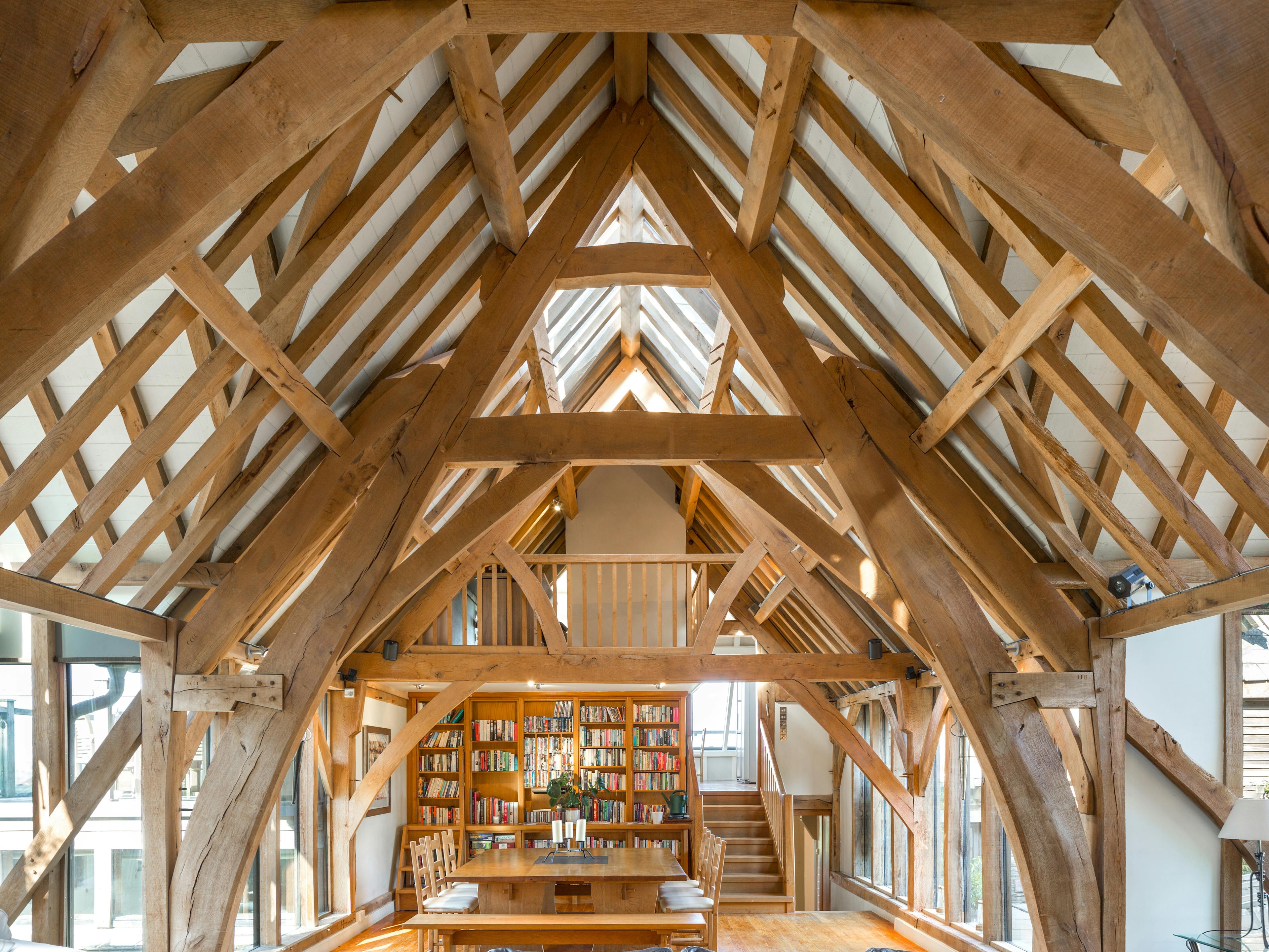 A large living sitting room with an oak frame cruck truss vaulted ceiling