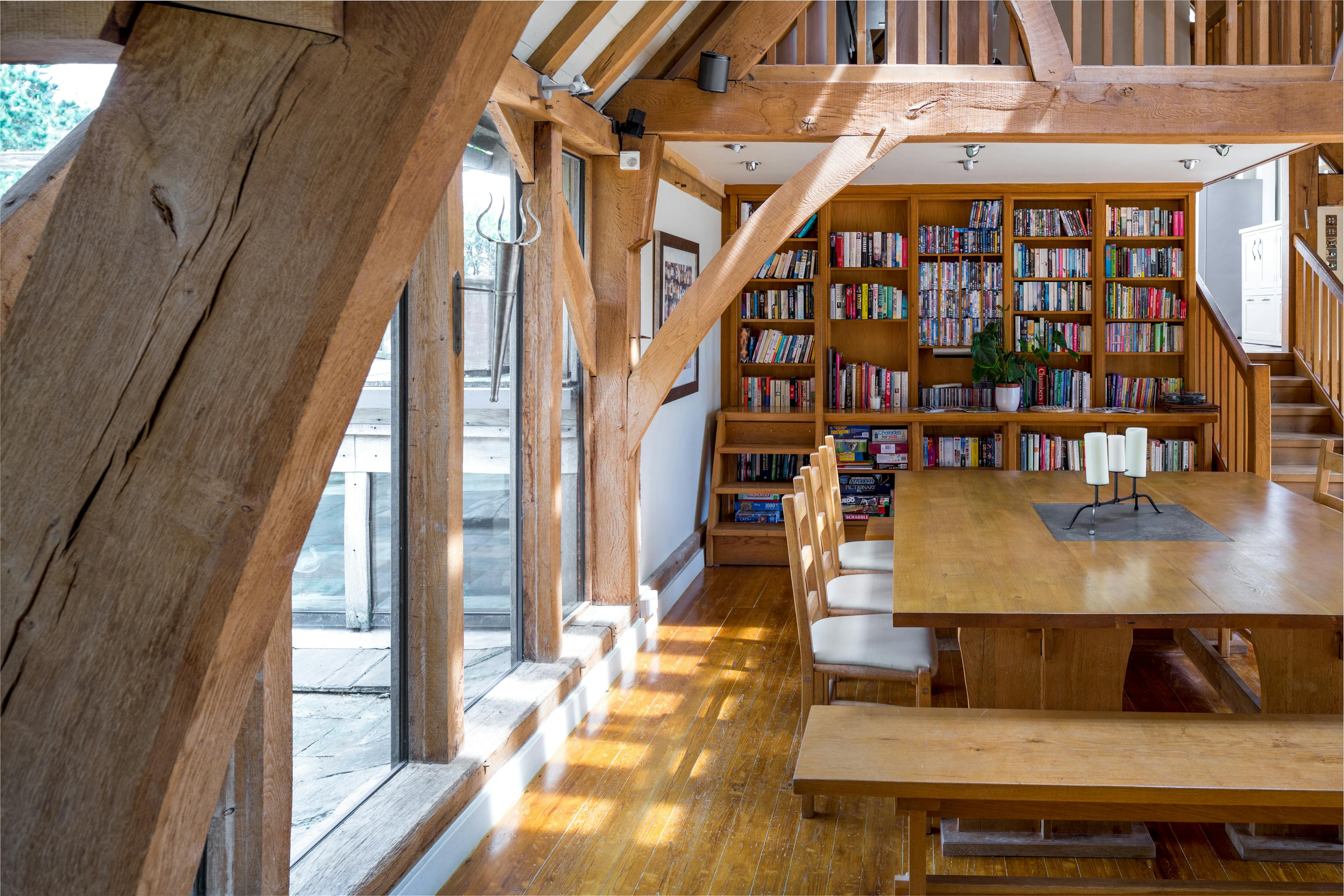 A large living sitting dining room with an oak frame cruck truss vaulted ceiling