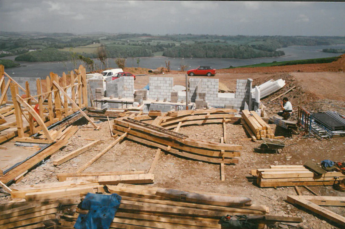 An oak frame with a cruck truss during installation on a construction site