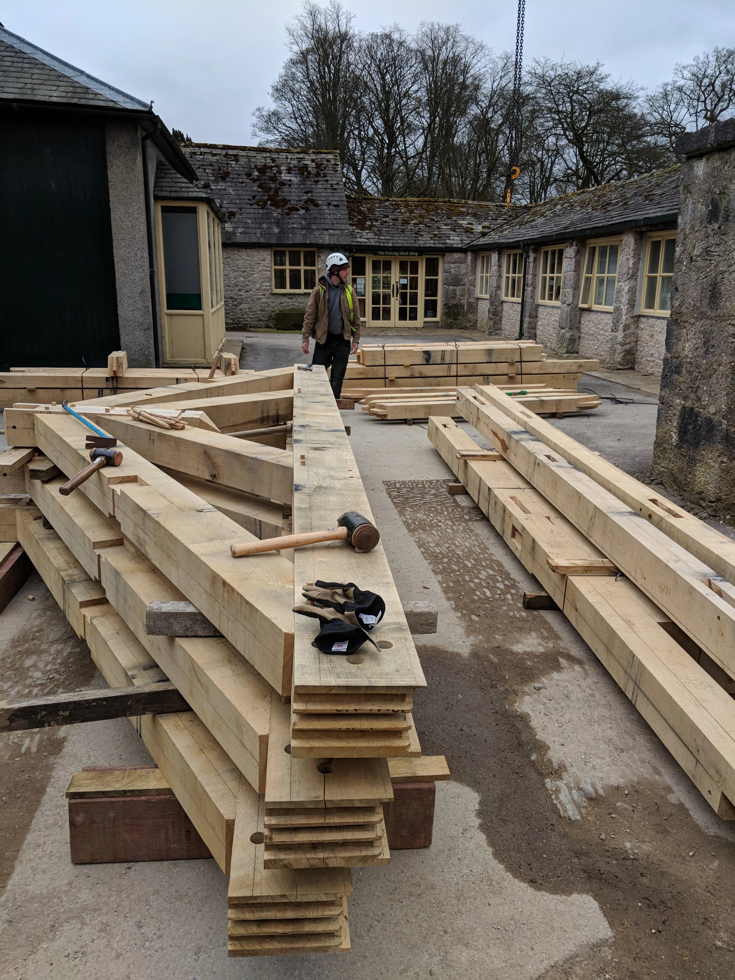 Oak trusses in a pile ready to be installed to create an oak framed cafe