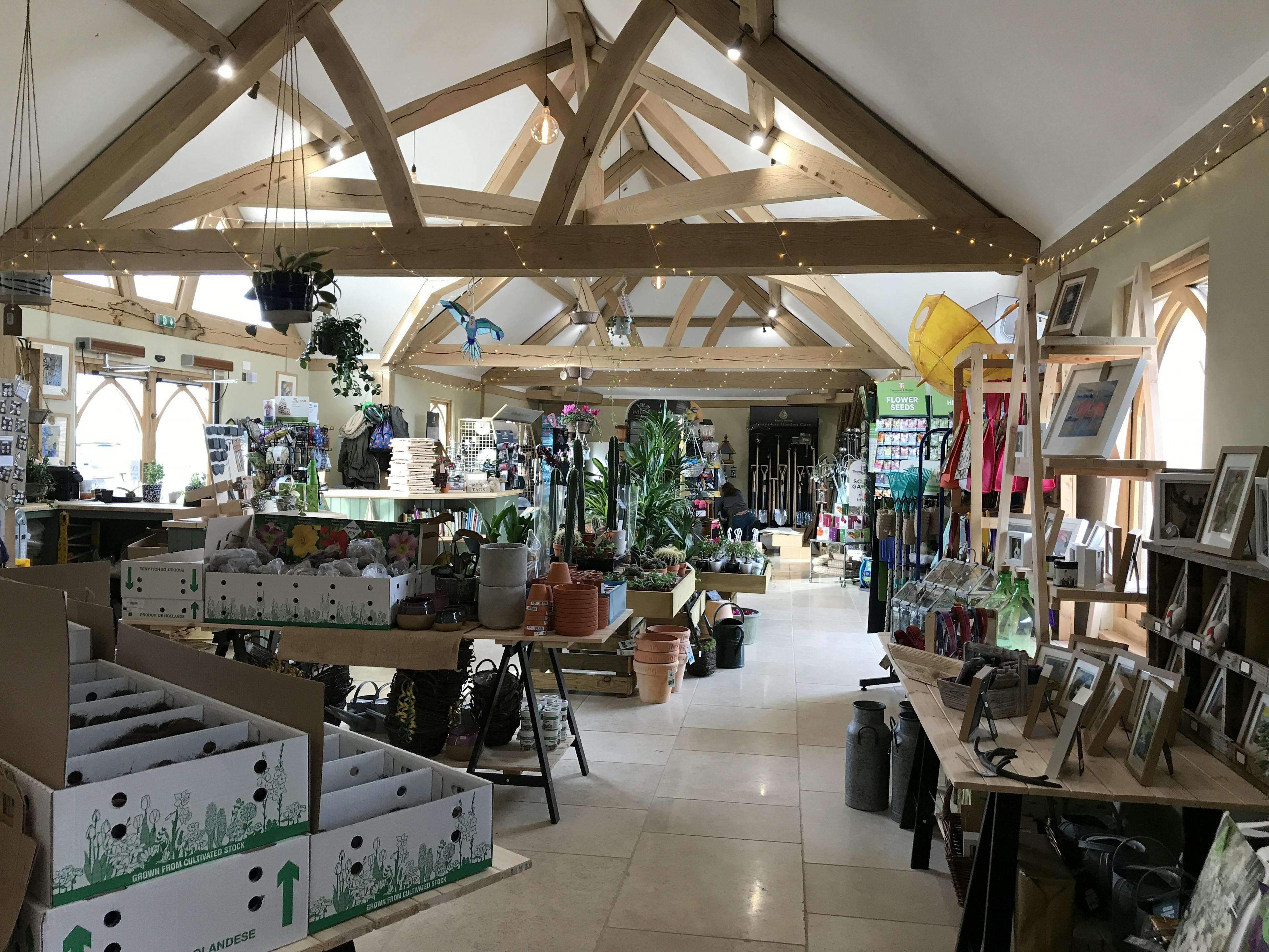 An oak framed garden centre with lots of items on sale