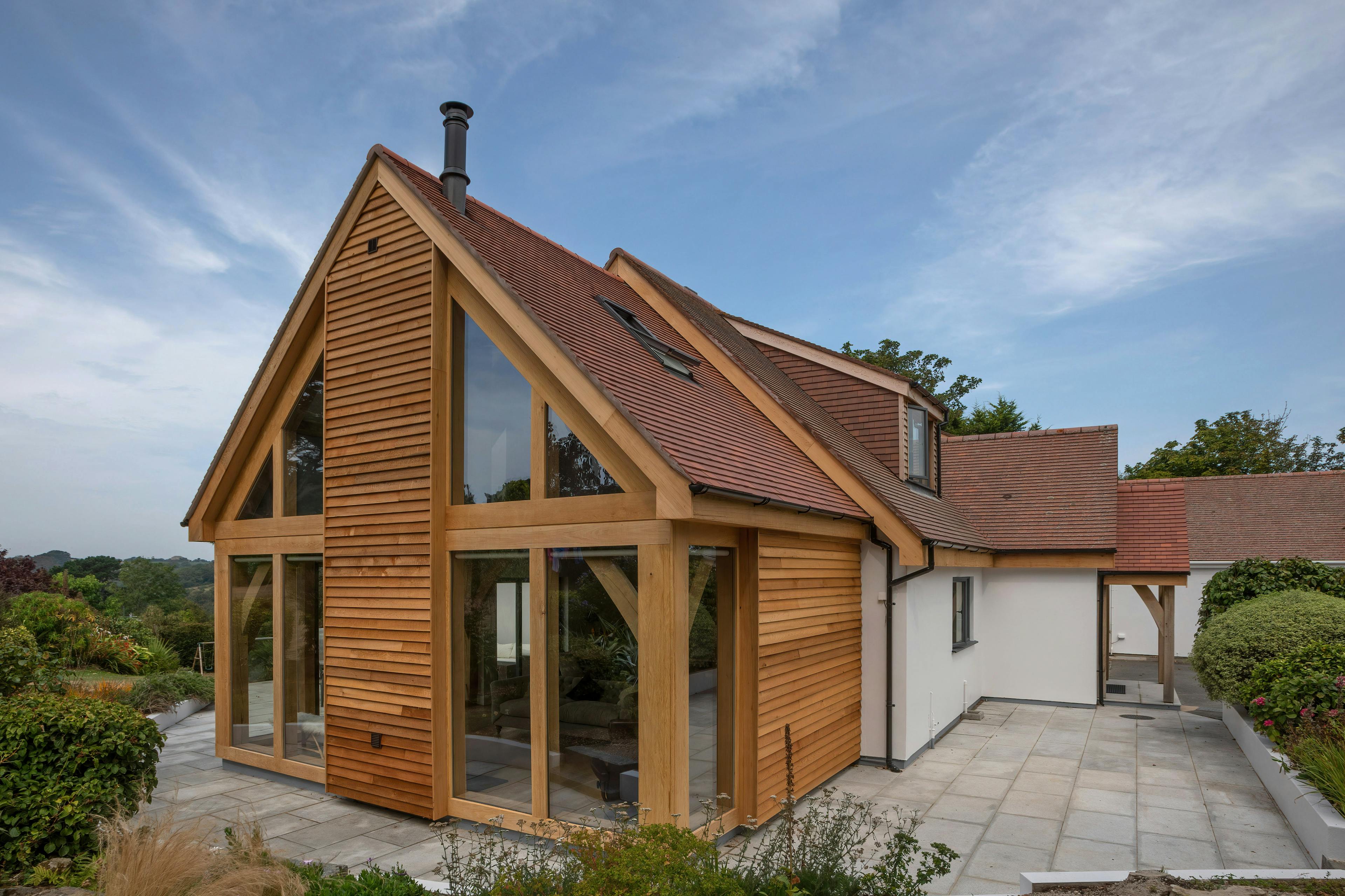 Exterior view of a contemporary bungalow with an oak-framed extension in Guernsey