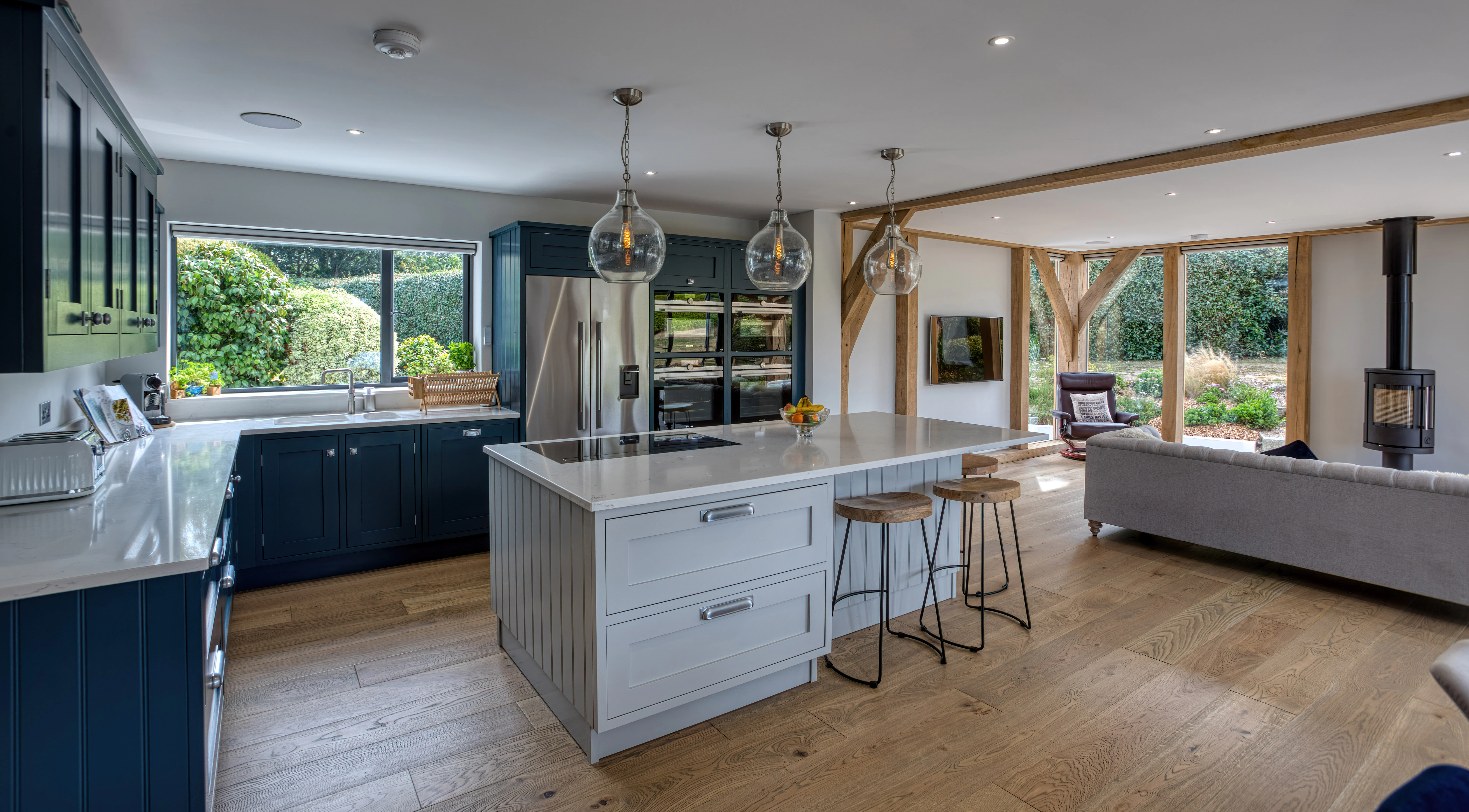 Interior view of an open-plan oak-framed extension, featuring a kitchen, dining area, and lounge space