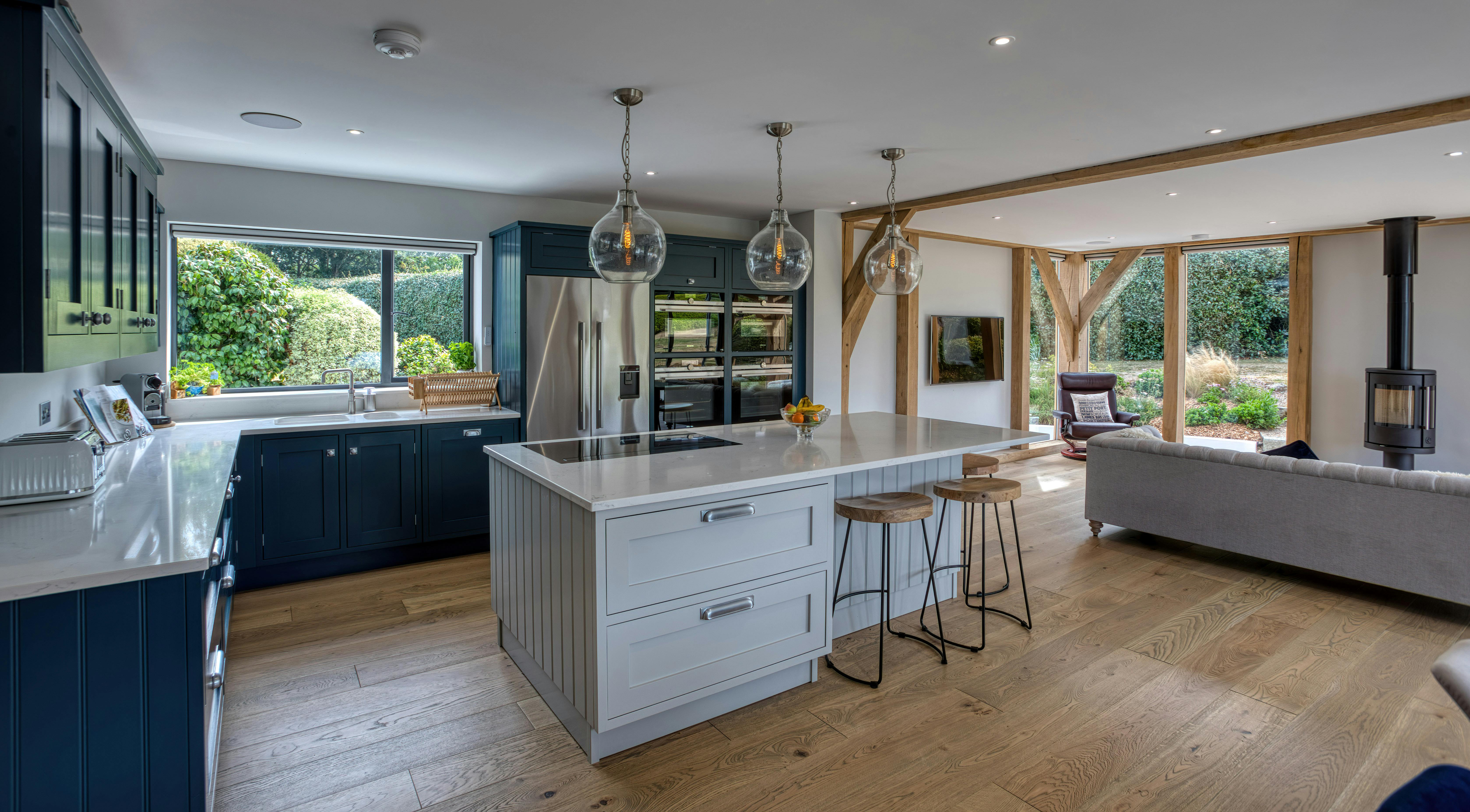 Interior view of an open-plan oak-framed extension, featuring a kitchen, dining area, and lounge space
