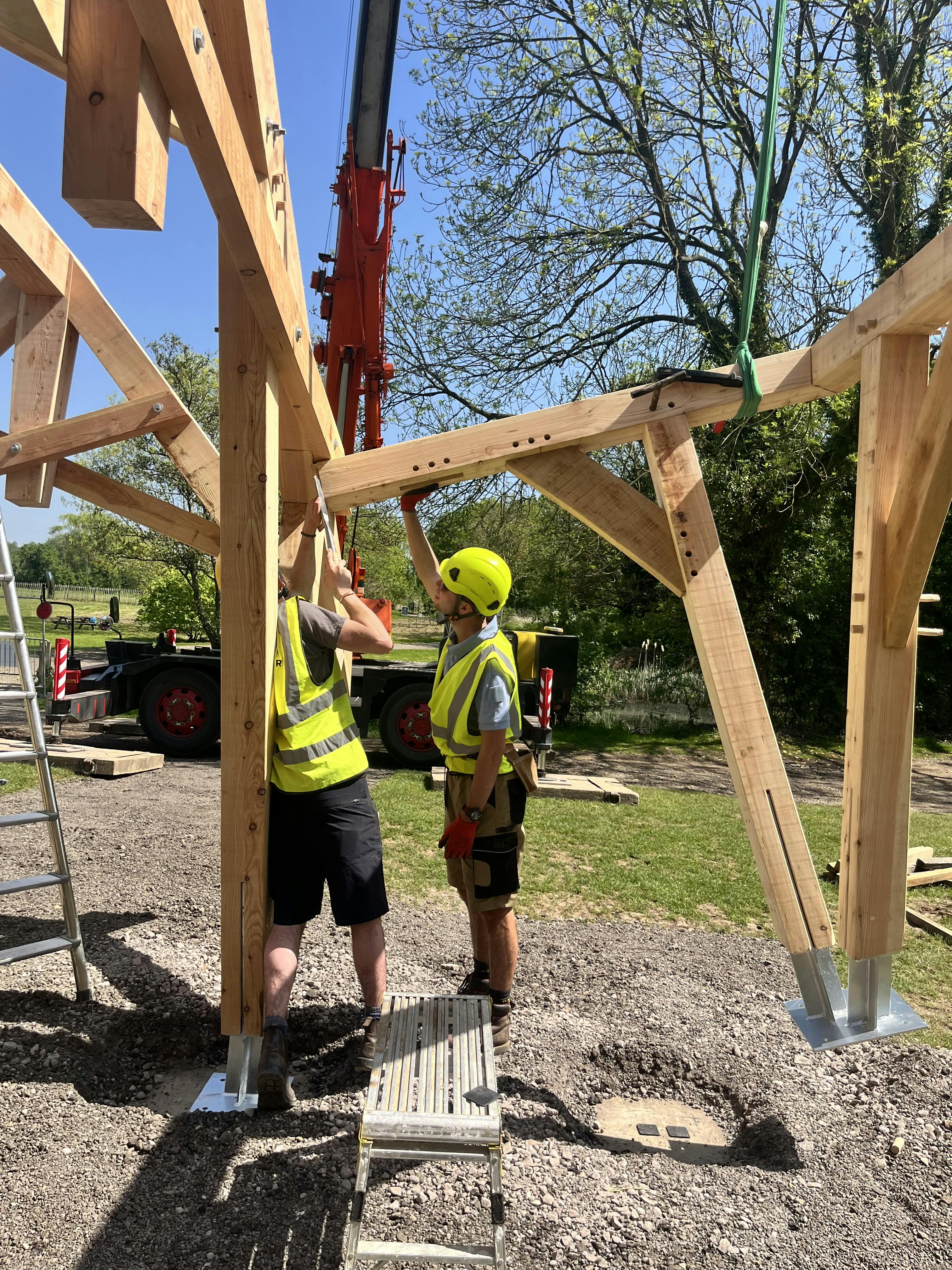 Carpenters working on a timber structured outdoor classroom during installation of the frame