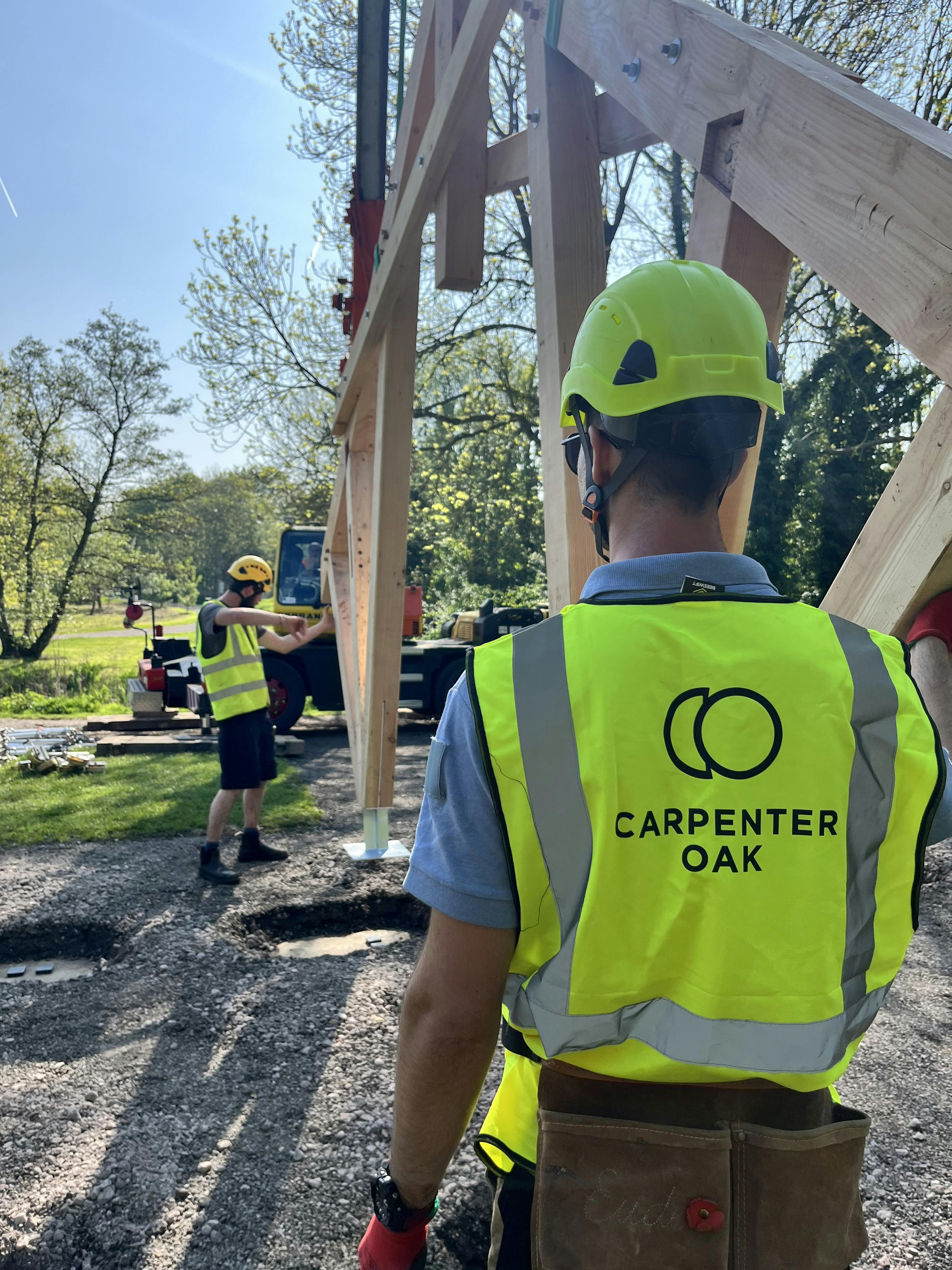 Carpenters working on a timber structured outdoor classroom during installation of the frame