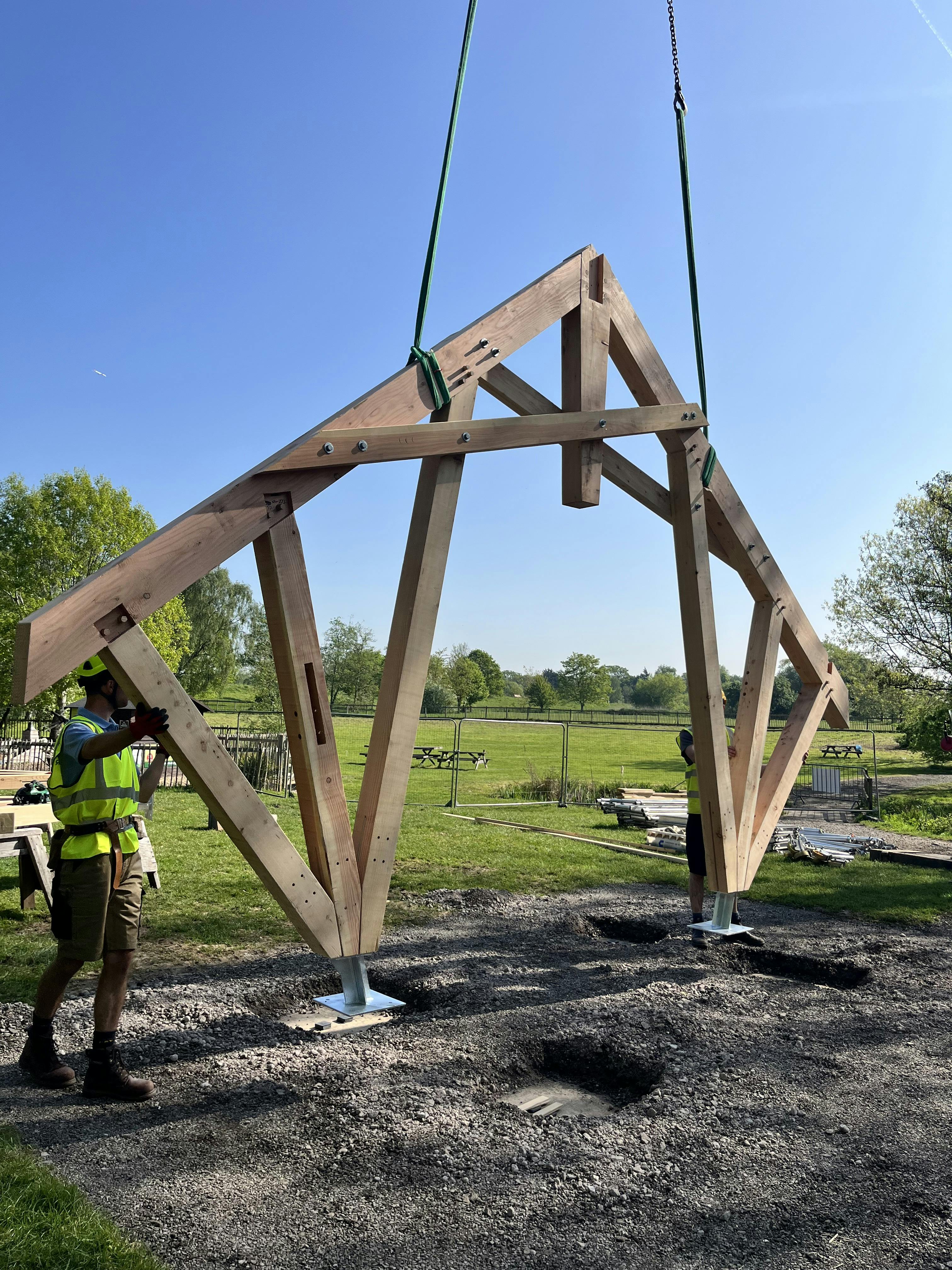 Carpenters working on a timber structured outdoor classroom during installation of the frame