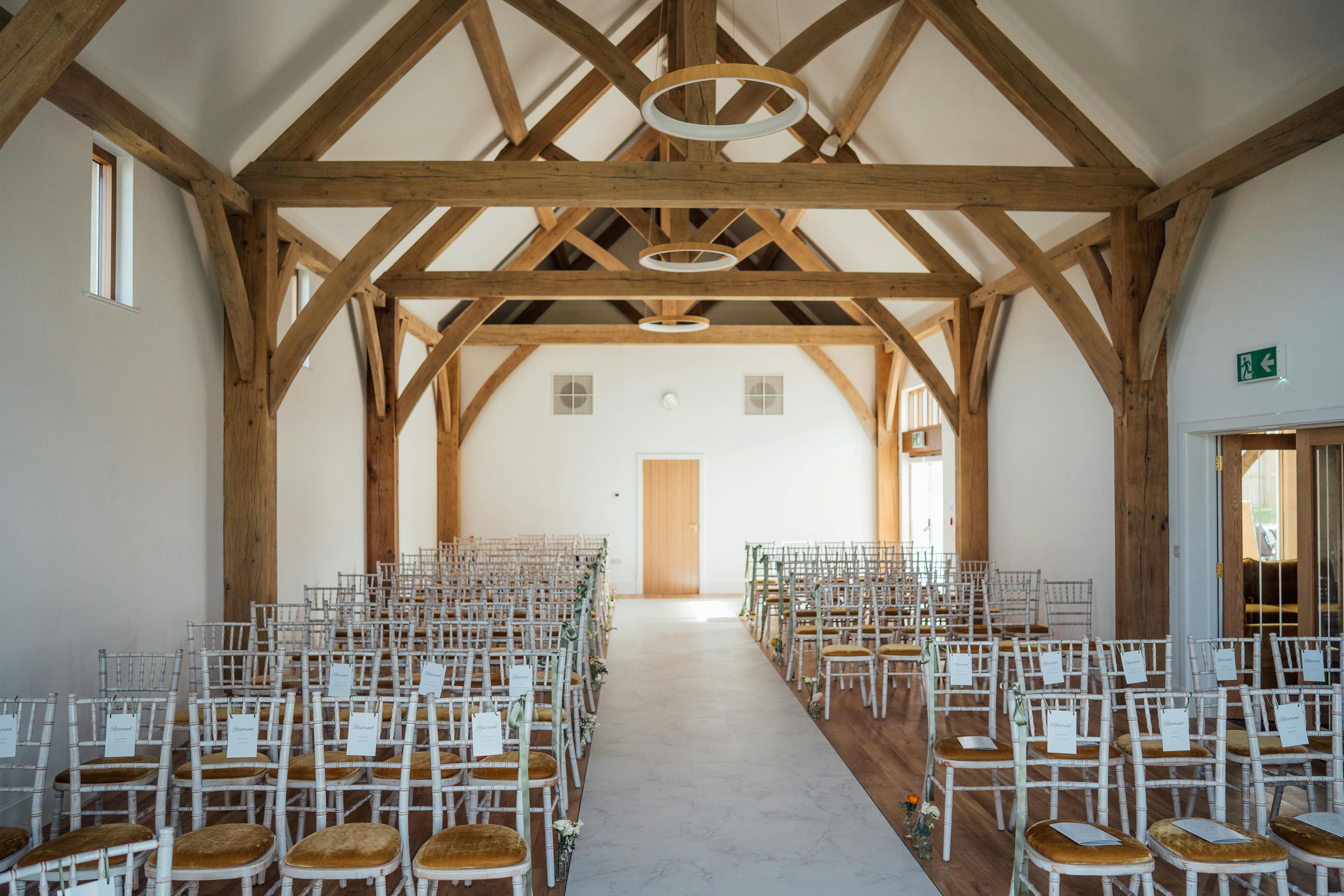The ceremony room in an oak framed wedding barn with large trusses