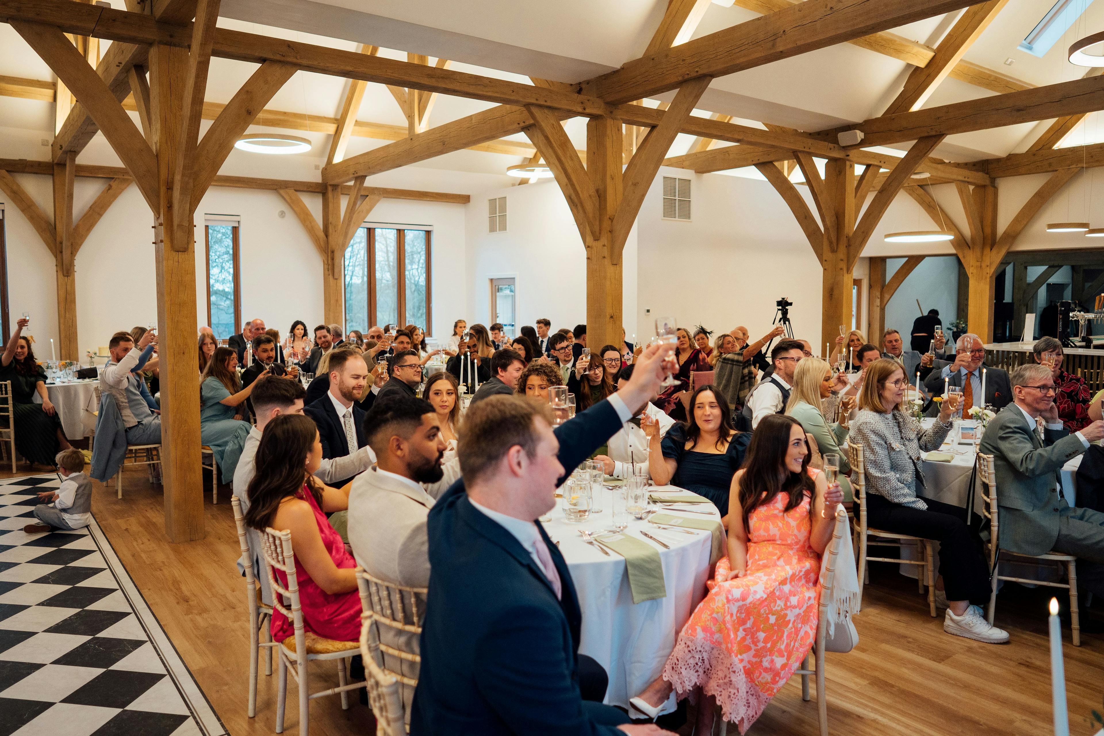 An oak framed wedding barn guests sat at tables